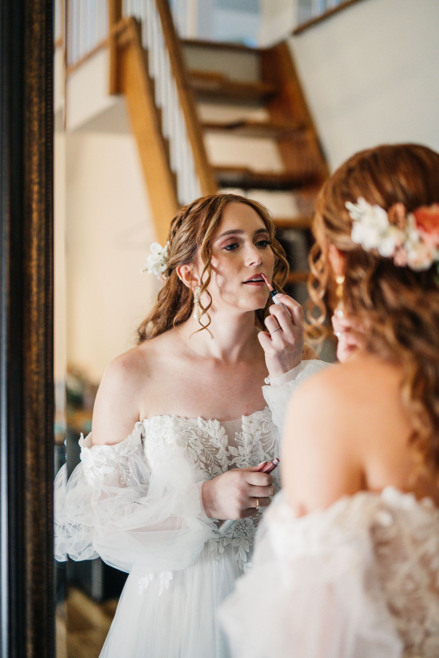 Wedding preparation scene with mirror reflection and white gown.