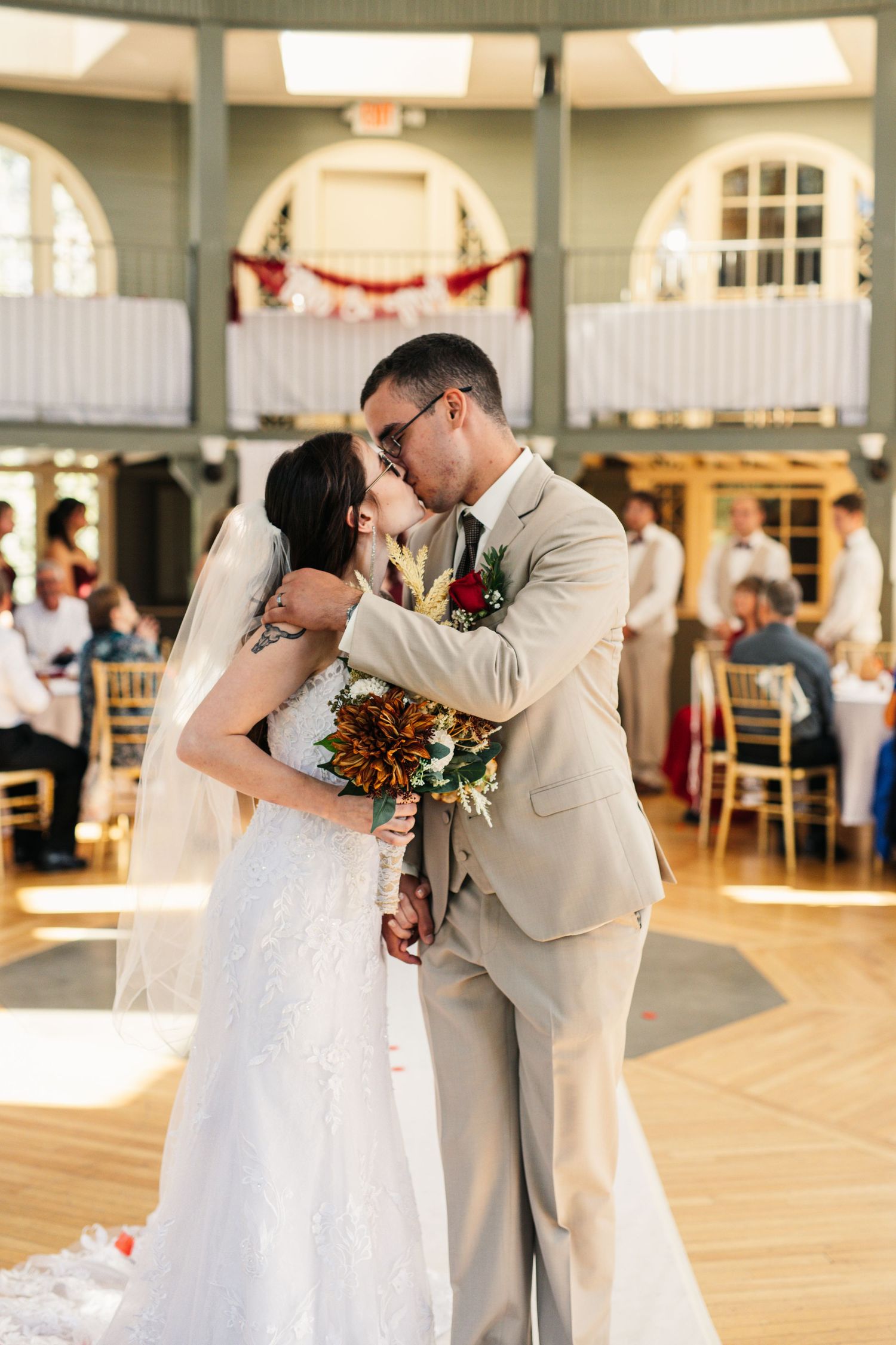 A wedding couple shares an intimate moment on a decorated indoor dance floor.