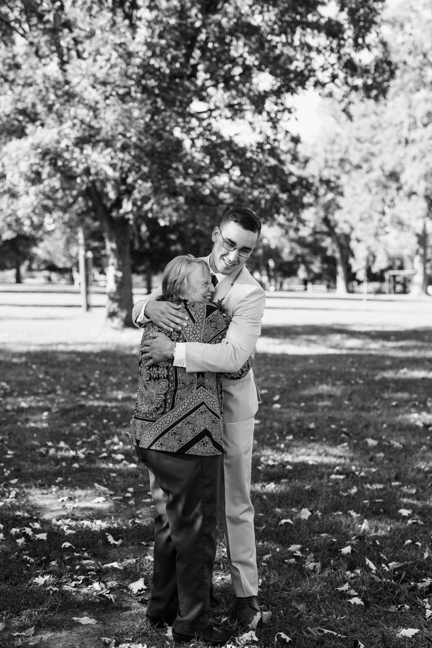 An emotional black and white photograph of an embrace in a park setting.