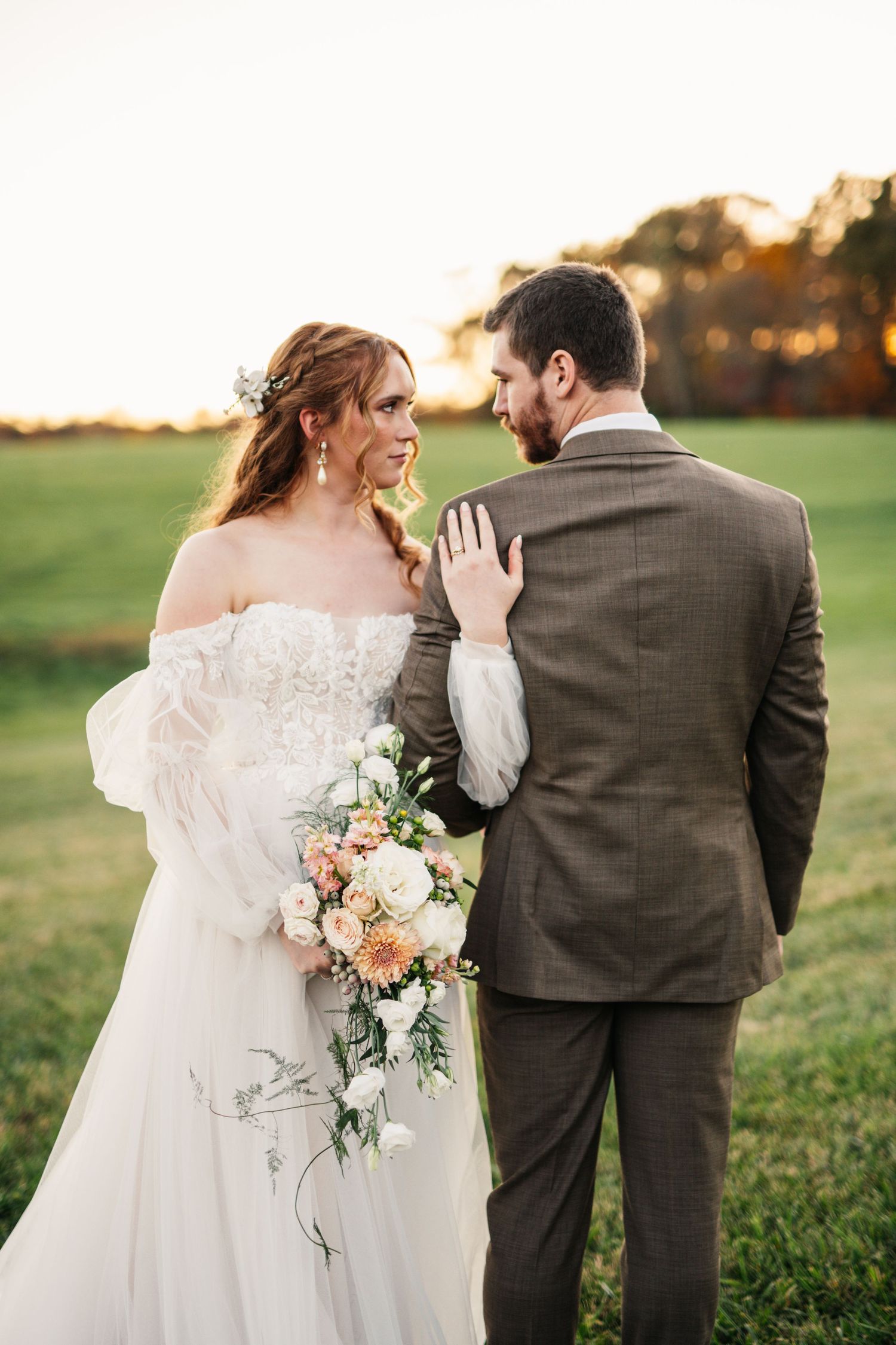 A romantic wedding portrait showing couple embracing in golden light.