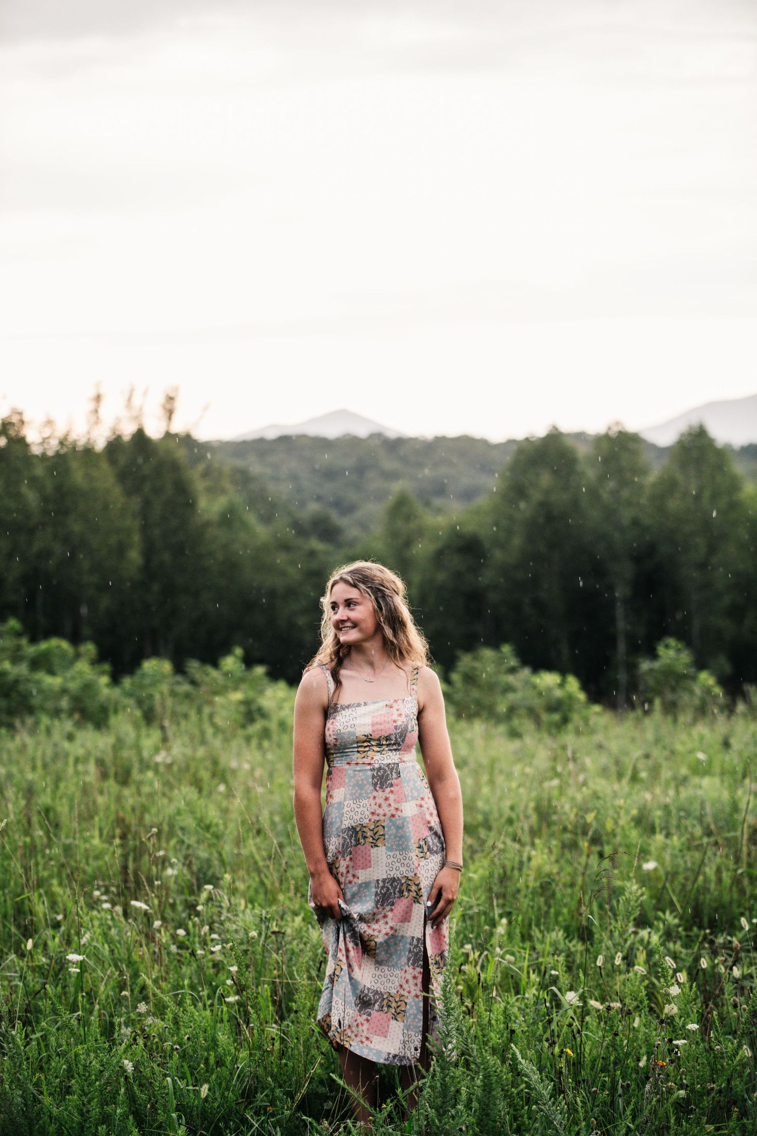 A summer evening portrait in a lush green meadow with mountain views.