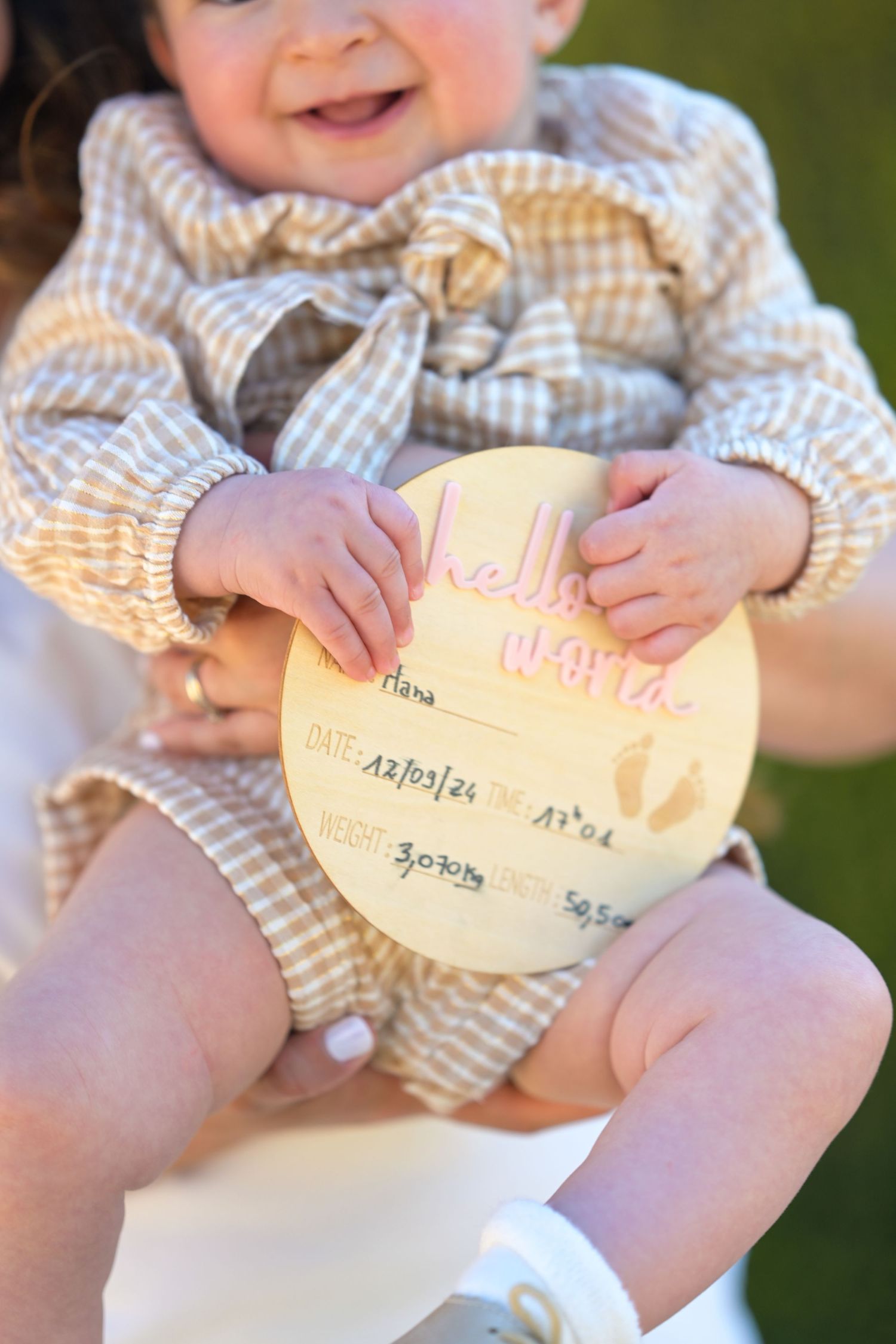 Small hands holding paper notes during an outdoor photo session.