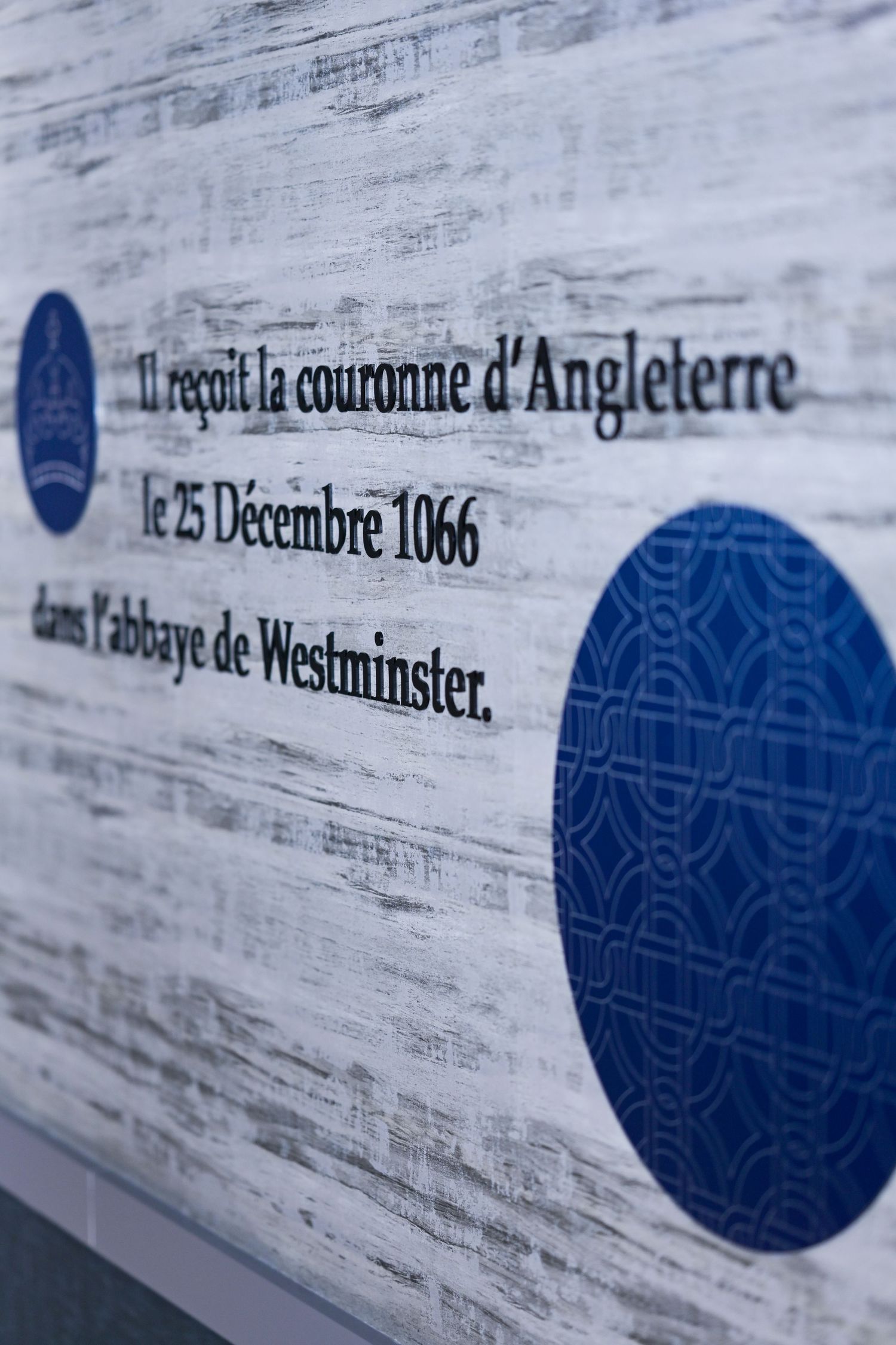 French text about the English crown in 1066 with blue circular decorative elements.