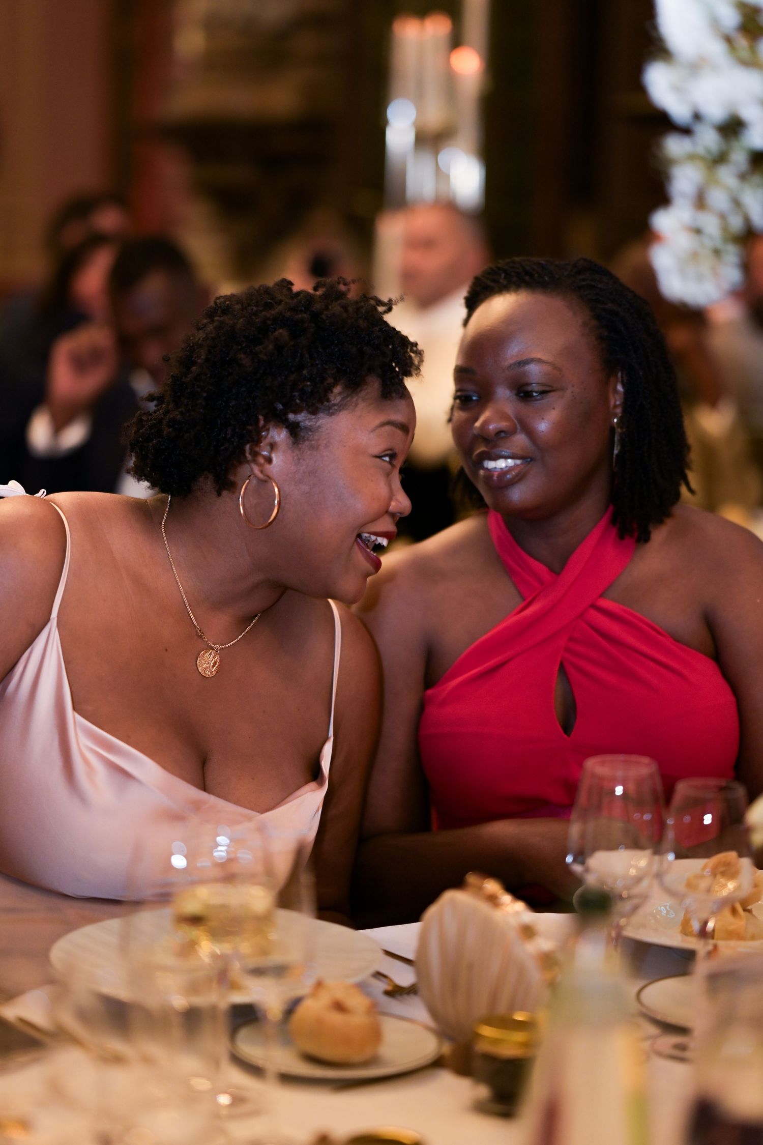 Two guests sharing a laugh during an elegant dinner reception.