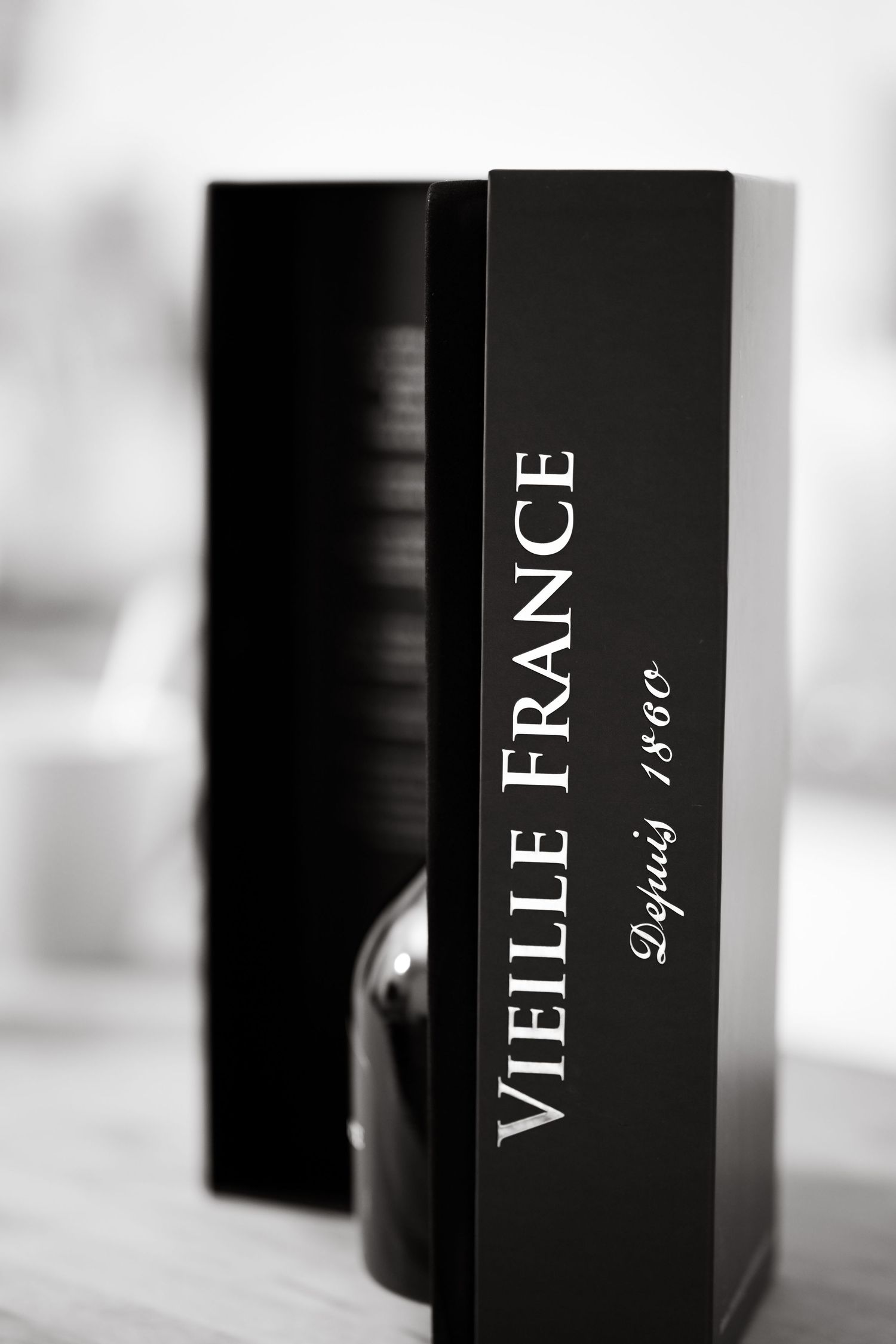 Black luxury perfume boxes arranged on a white shelf display.