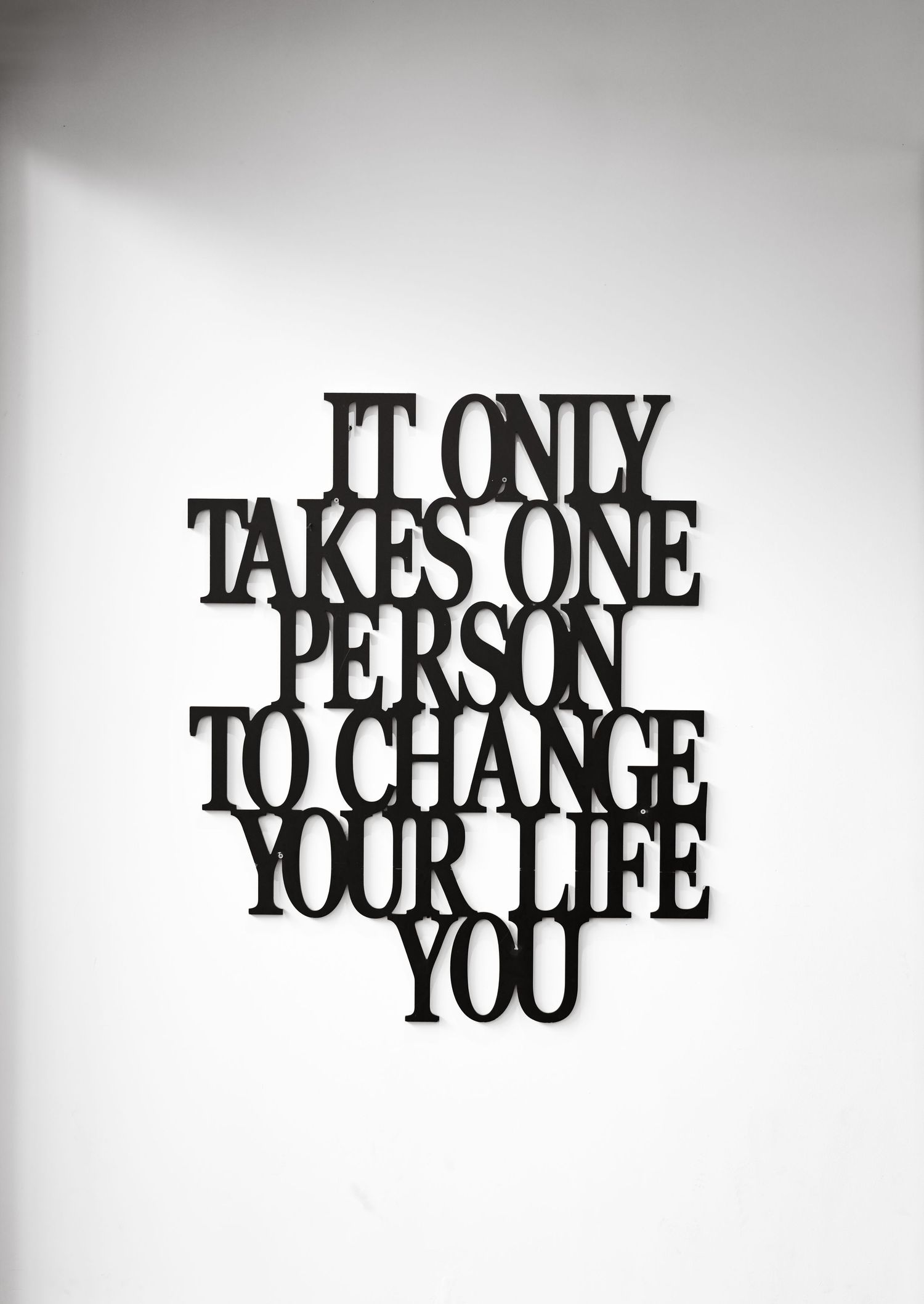 Black text art installation spelling out inspirational message against white background.