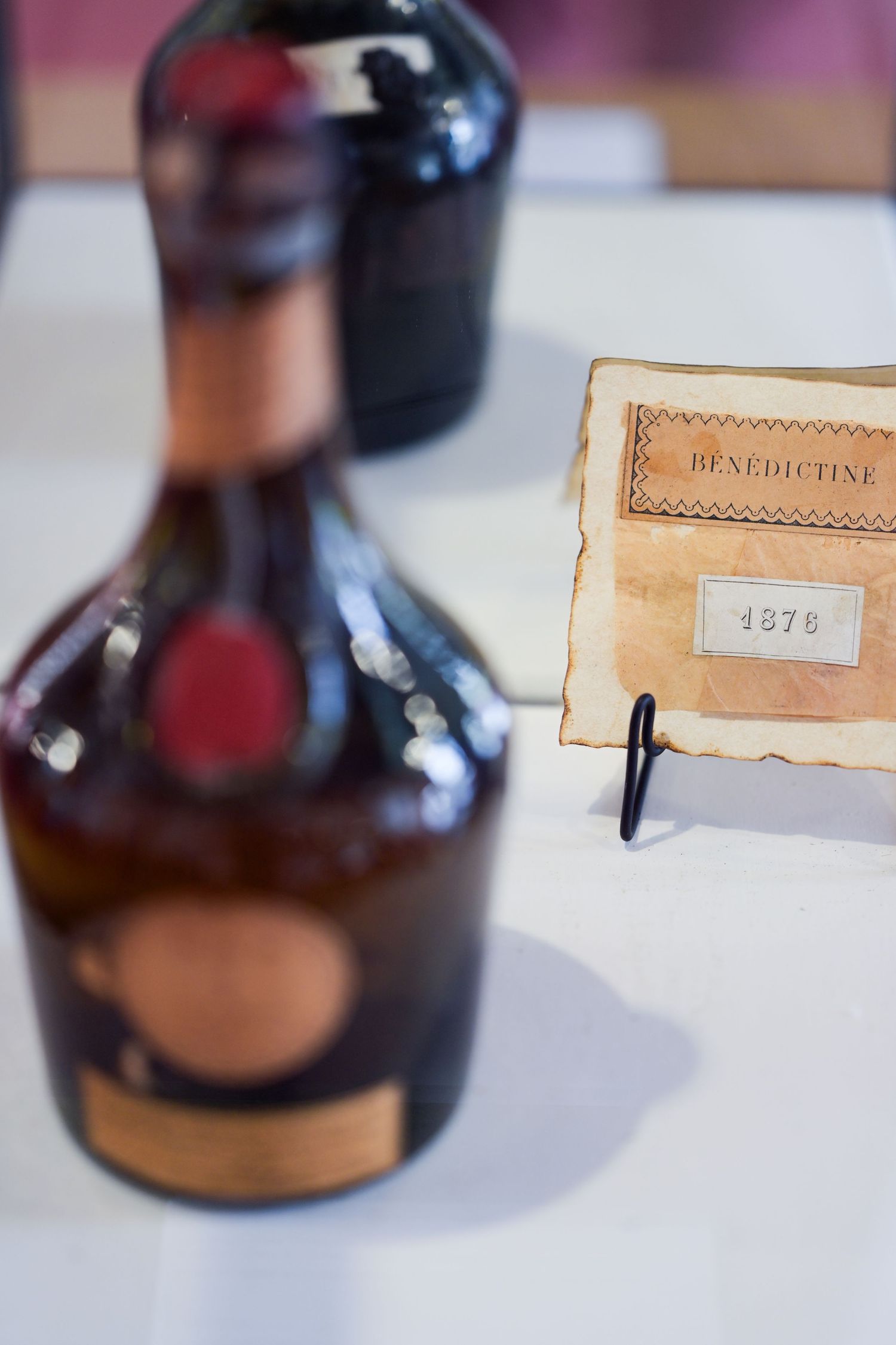 Vintage Benedictine bottle displayed next to an antique label from 1976.