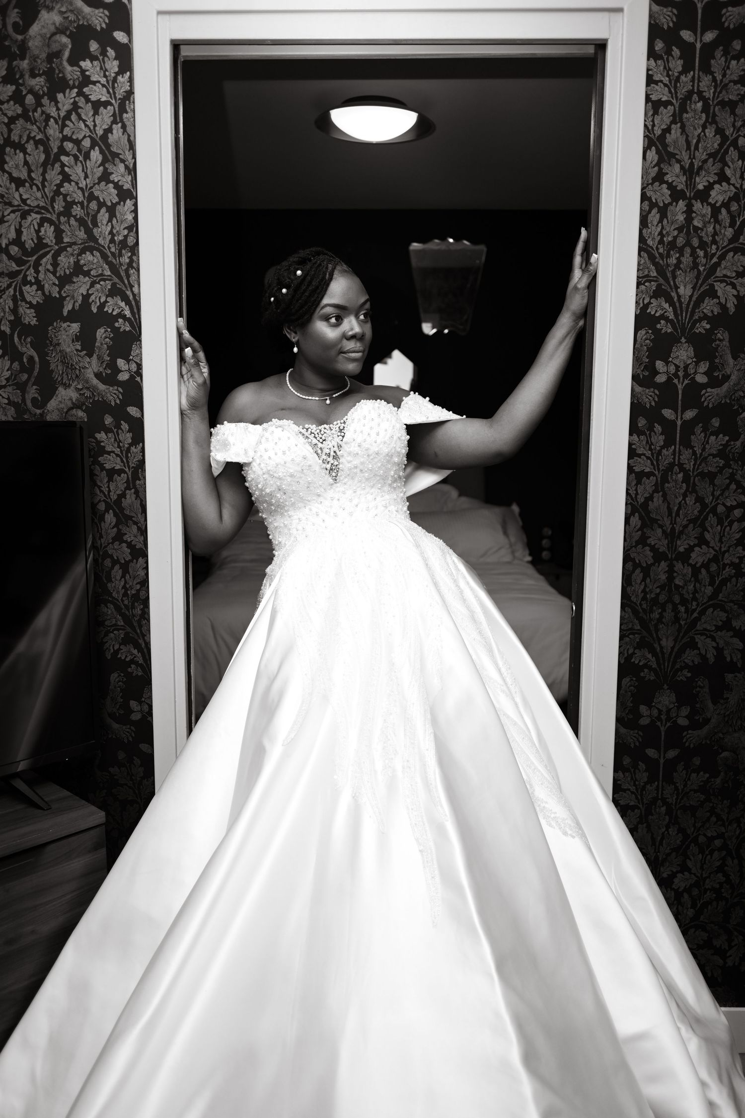 A stunning wedding dress portrait in black and white with dramatic framing.