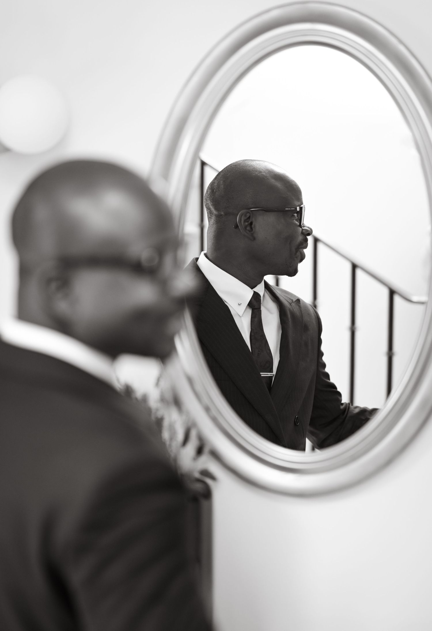 Black and white image of circular mirrors on a wall creating artistic reflection.