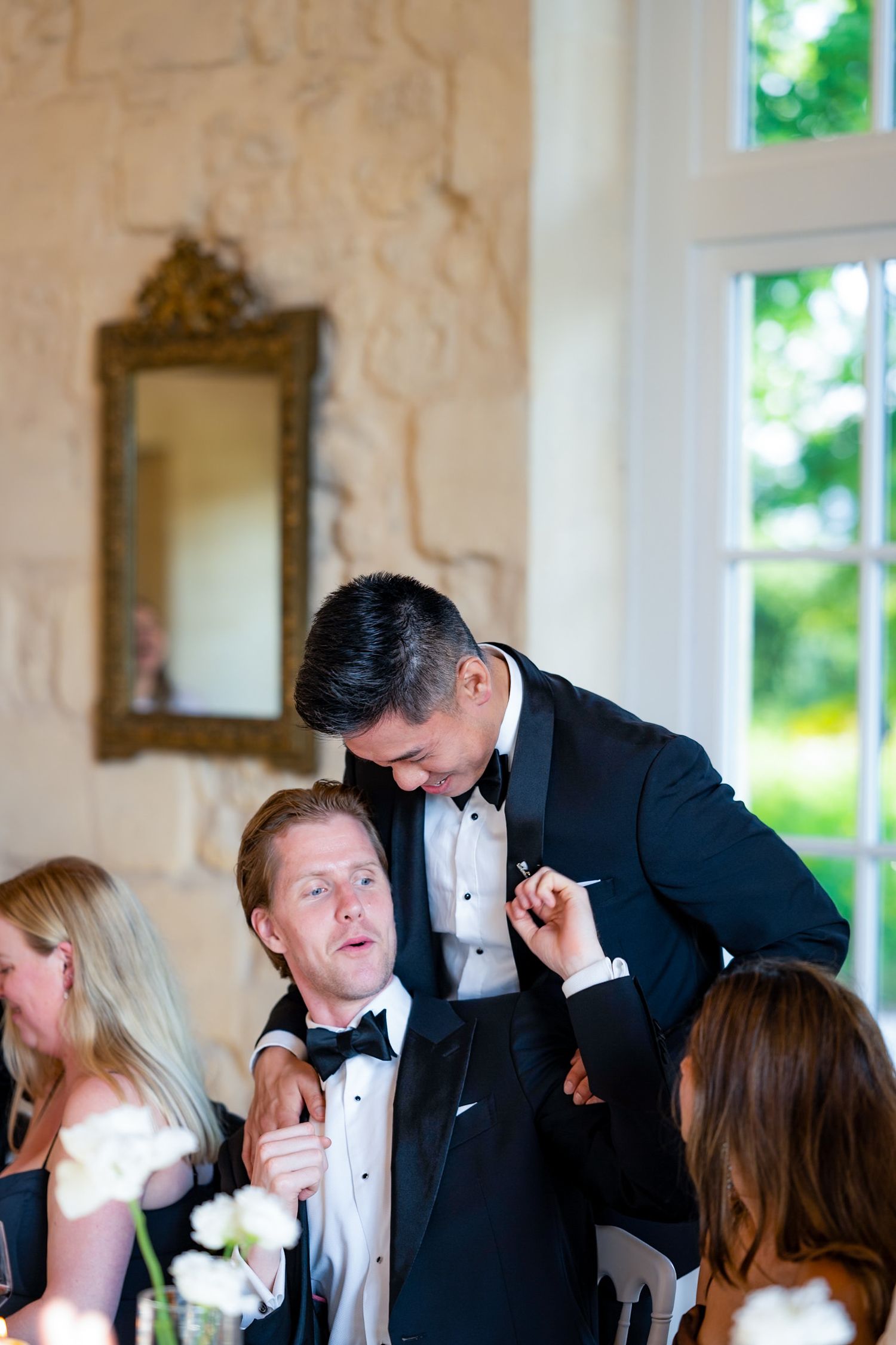 Guests in formal attire sharing a moment at an elegant dinner reception.