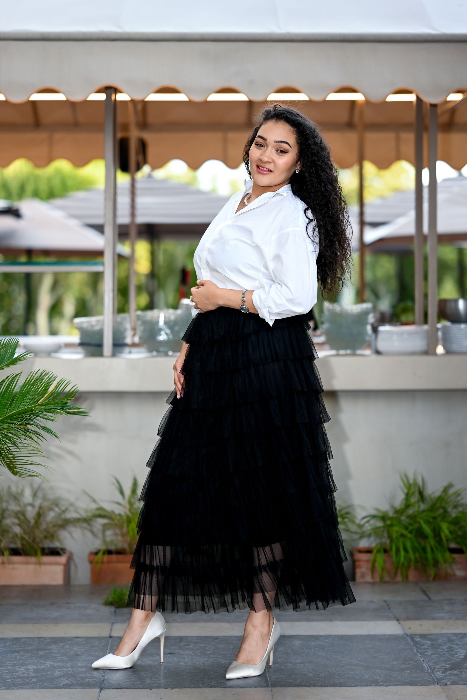 Fashion portrait showcasing elegant contrast between crisp white top and layered black tulle skirt.