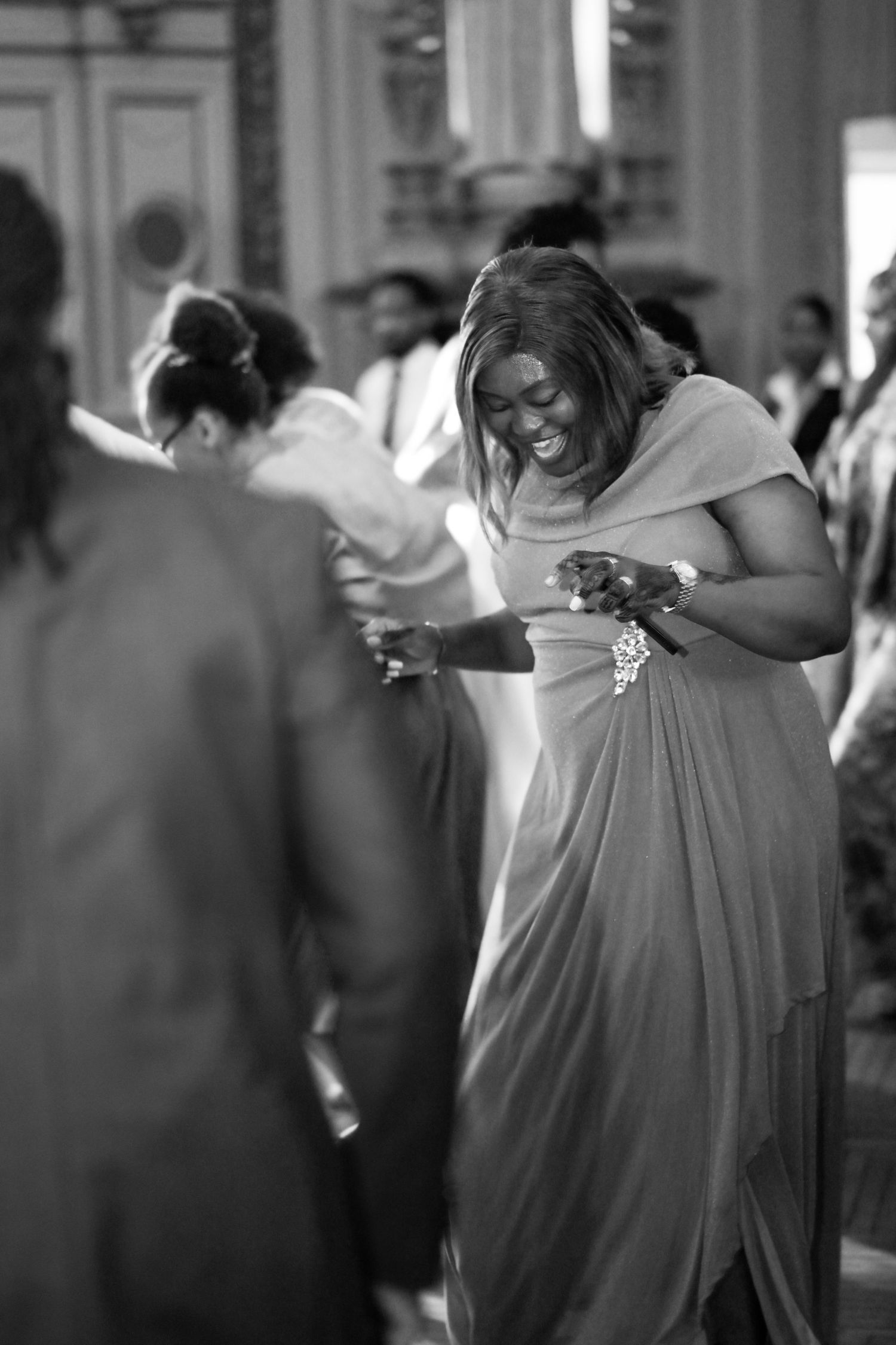 Candid black and white shot of dancers moving gracefully at an indoor event.