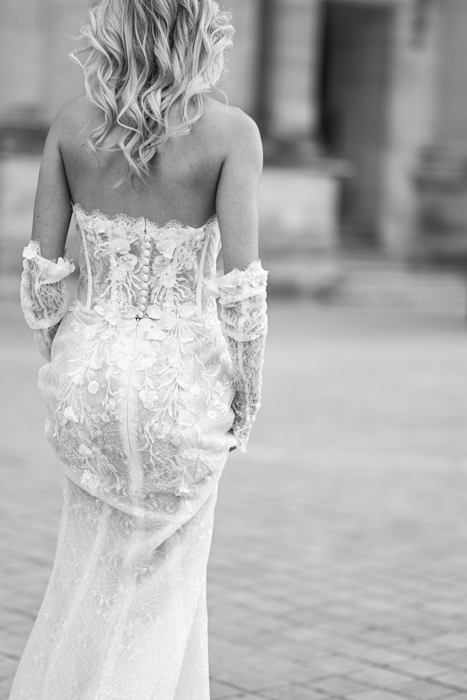 Close-up details of an intricate white lace wedding dress with delicate embroidery.