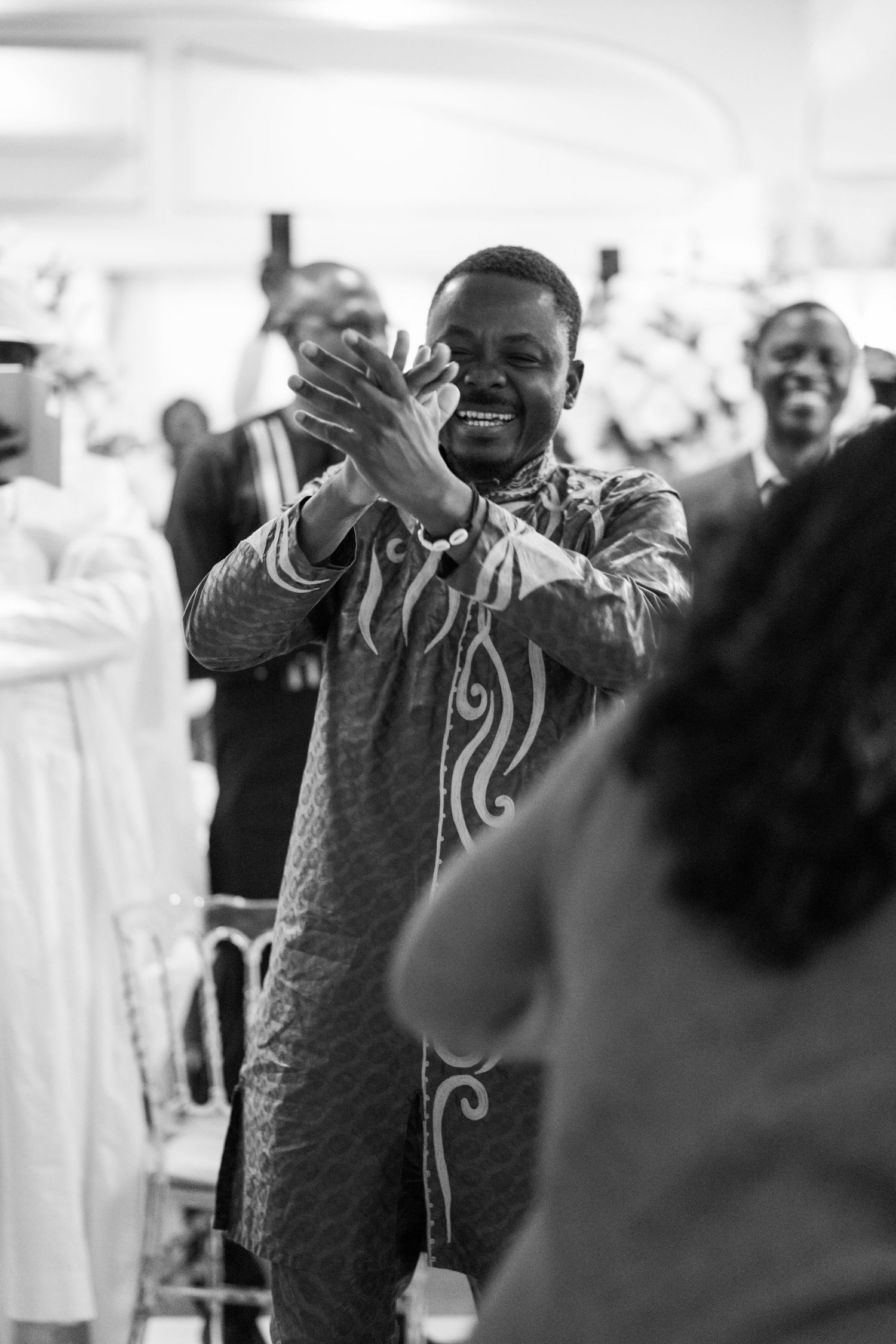 Person in formal attire gesturing expressively during what appears to be a celebration.