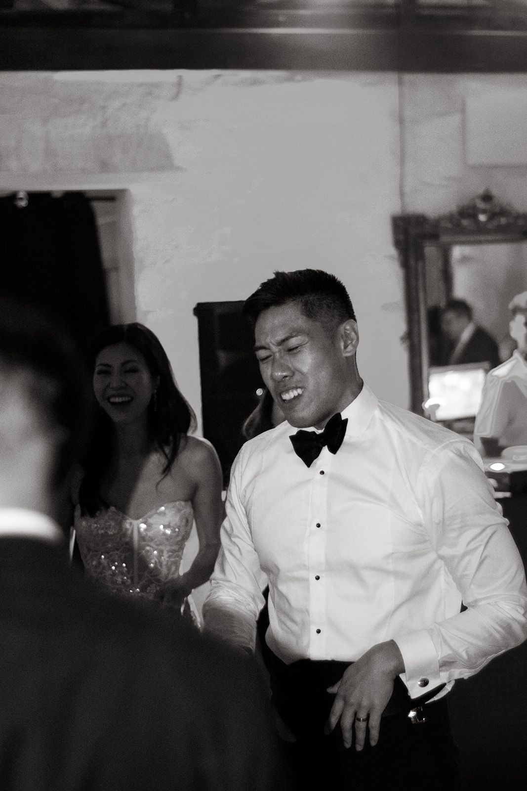 Black and white photo of formal event guests dancing and celebrating.