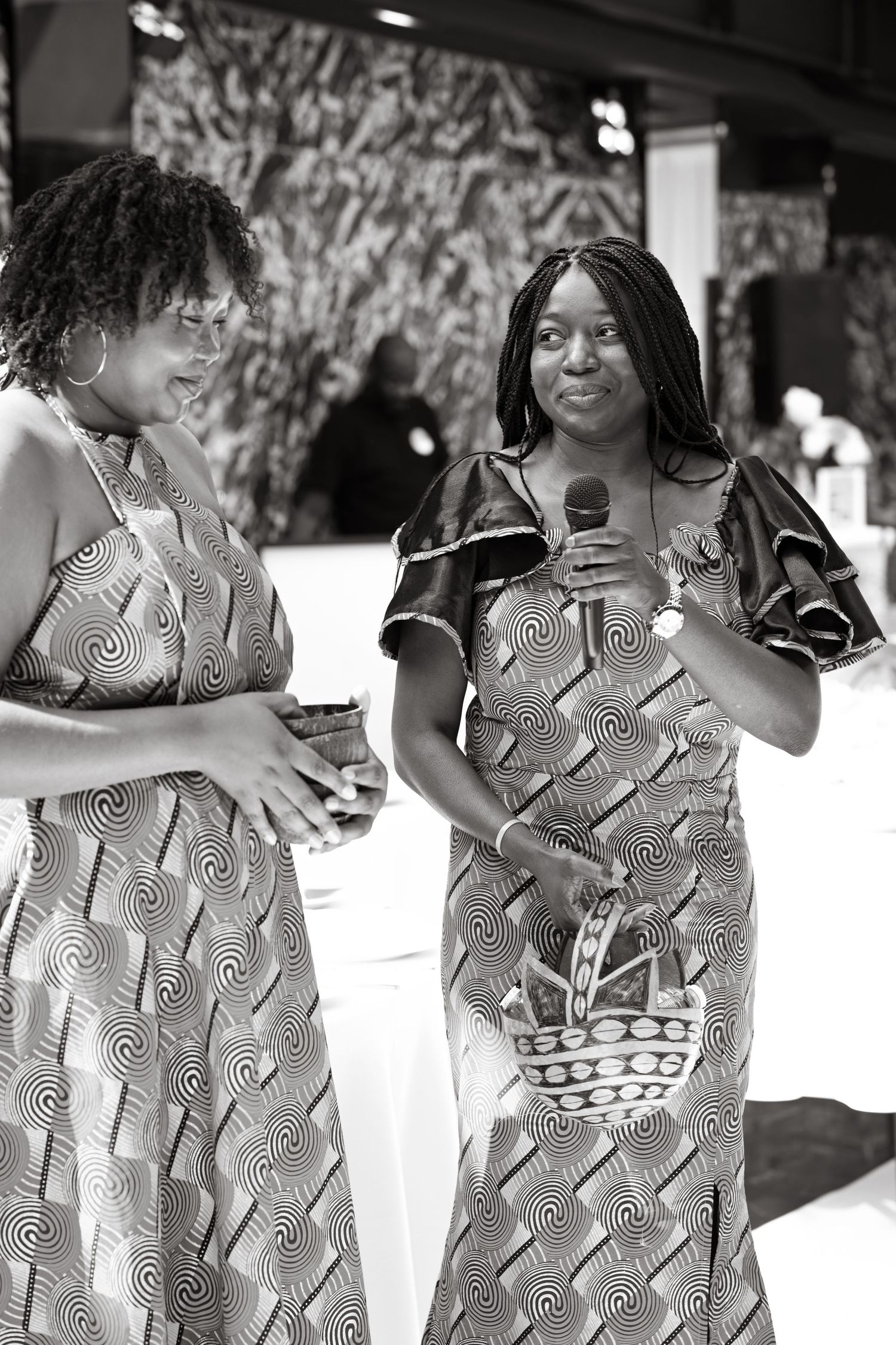 Group wearing patterned dresses in black and white sequence.
