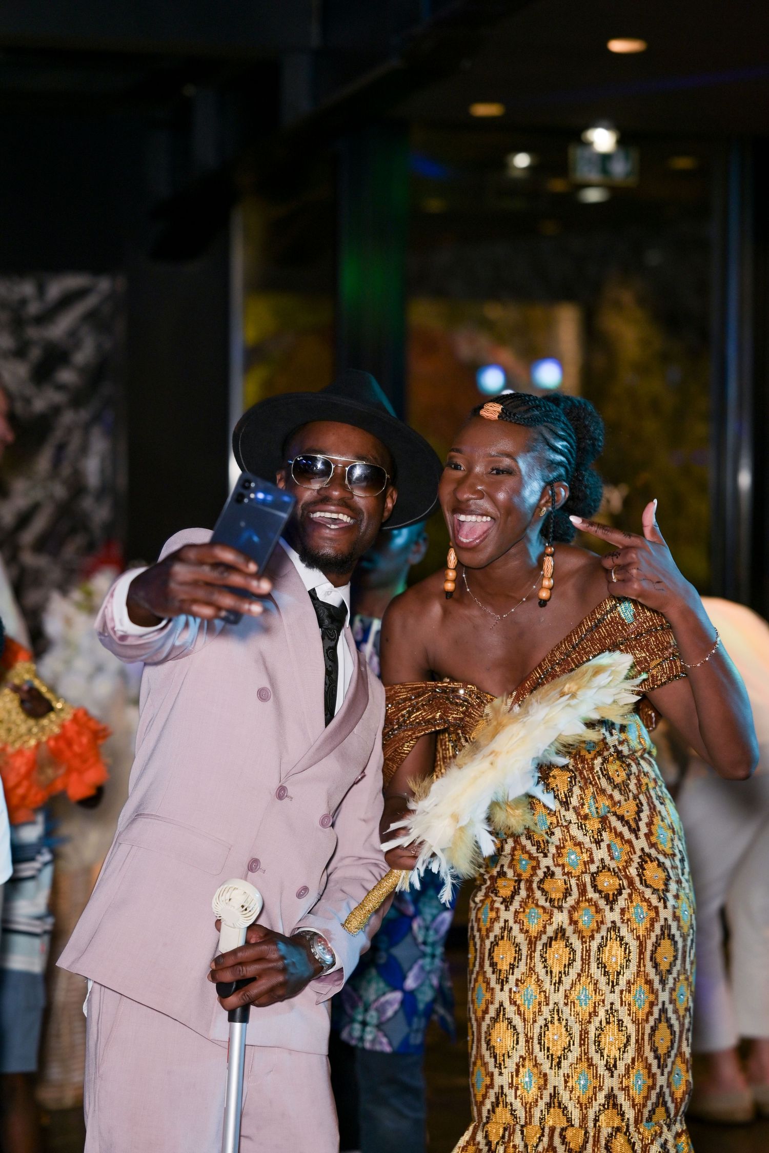 Two people sharing a joyful moment while dancing together at a celebration.