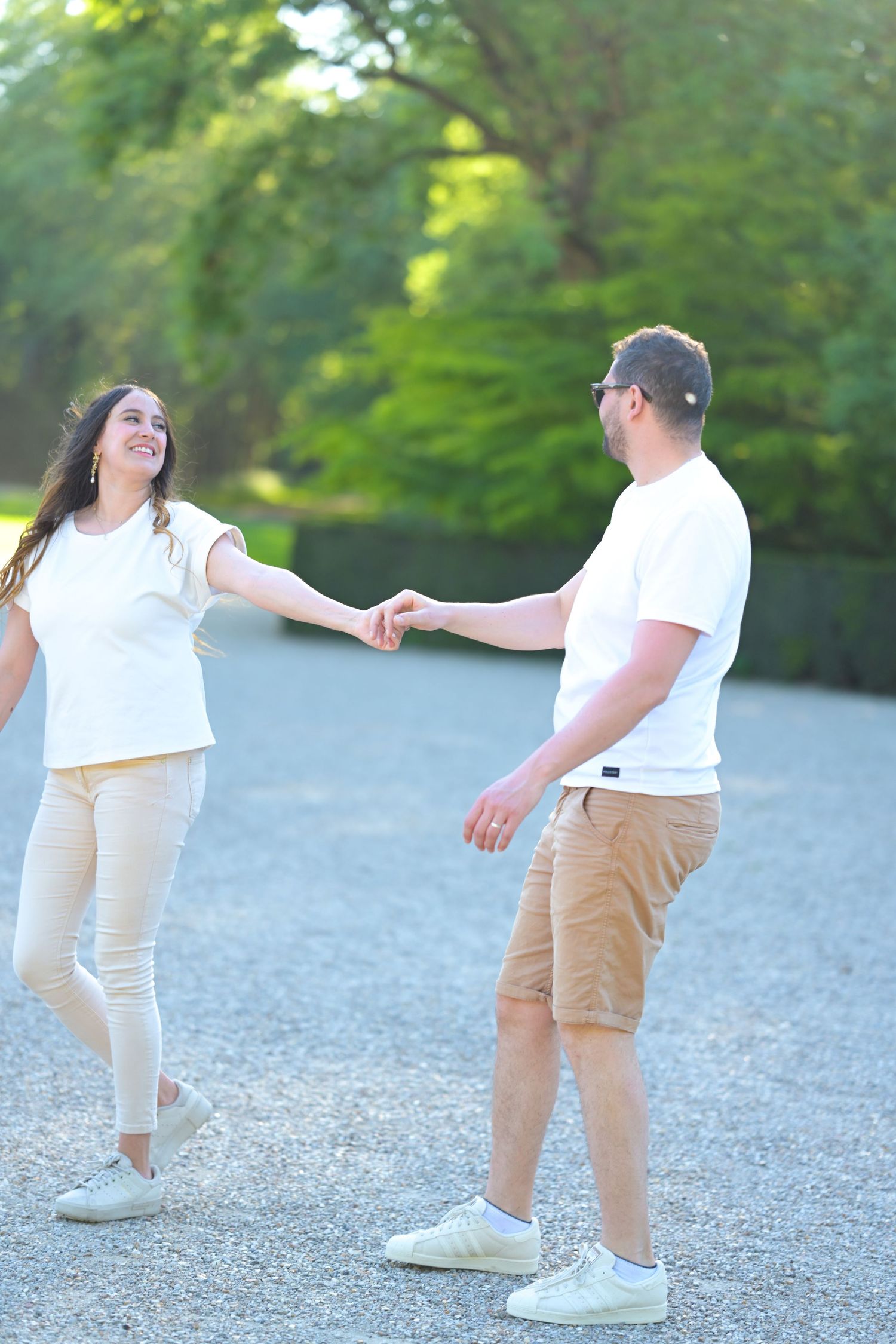 Playful interaction between people wearing coordinated outfits on gravel path.