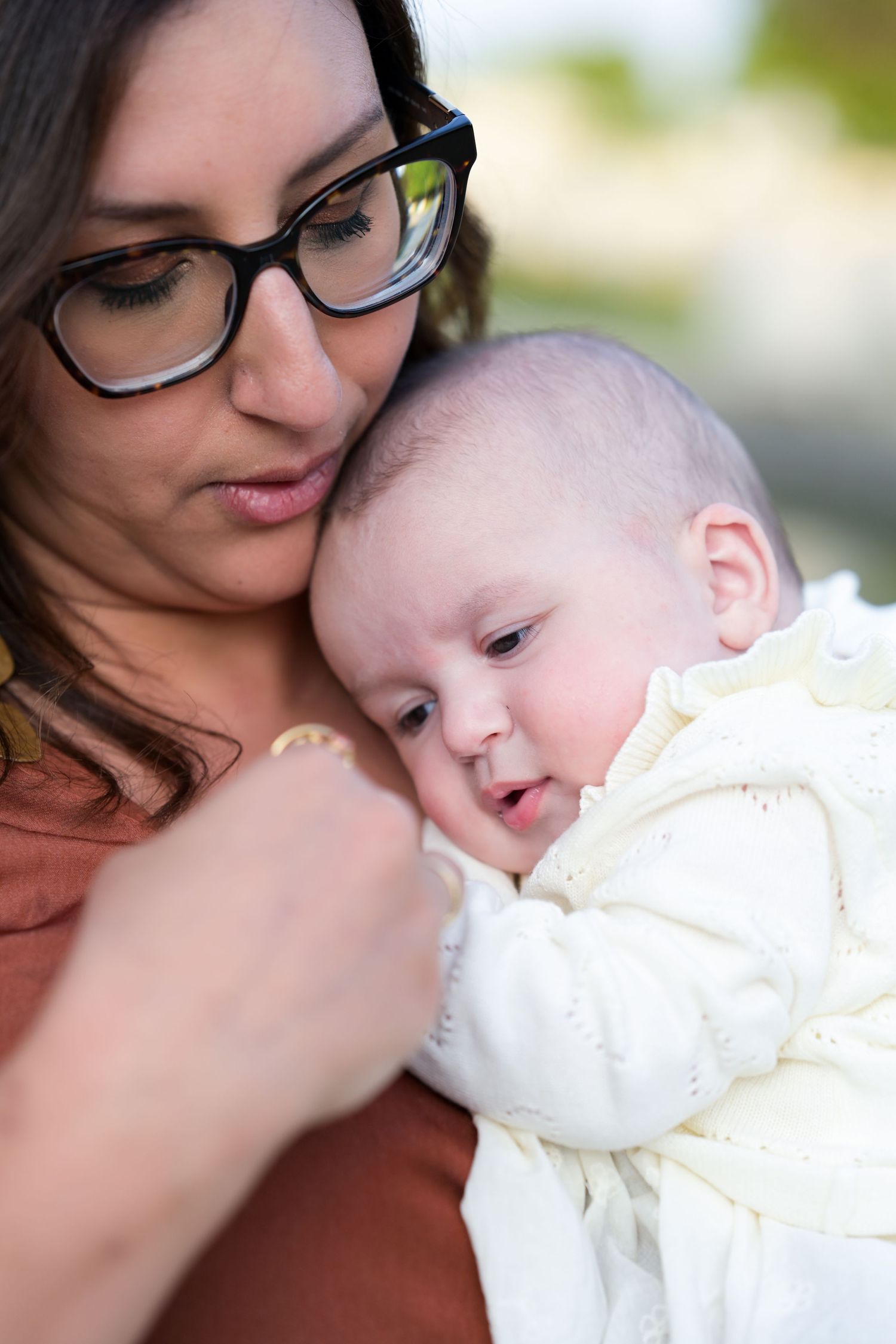 Tender close-up moments between parent and baby in soft natural light.