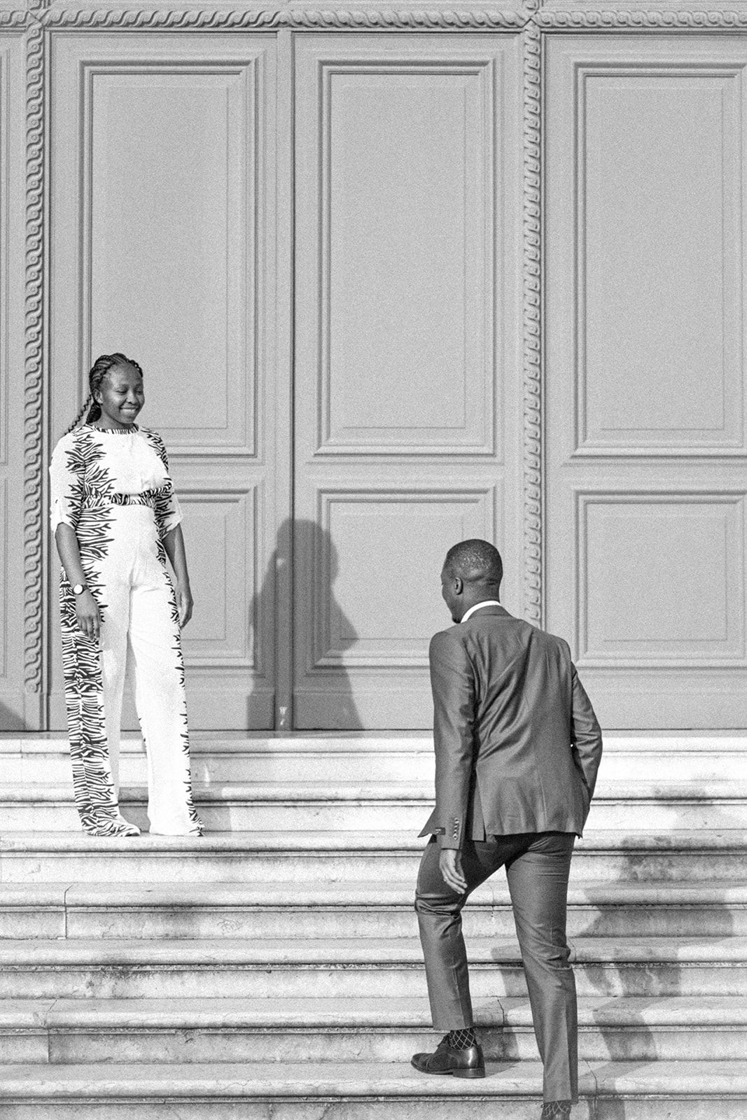 Artistic black and white shot of two people ascending stone steps.
