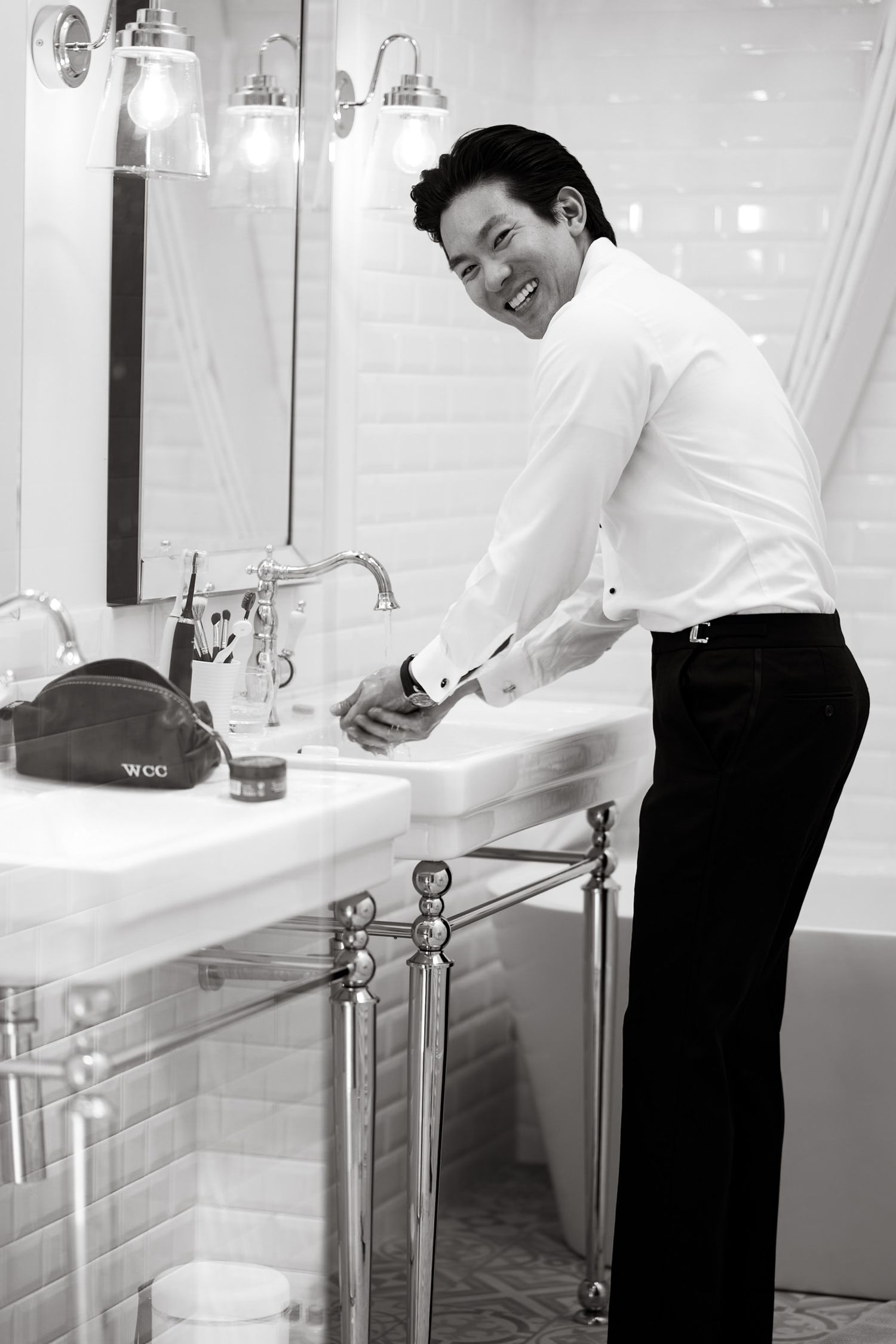 Modern bathroom interior with person washing hands at elegant sink.