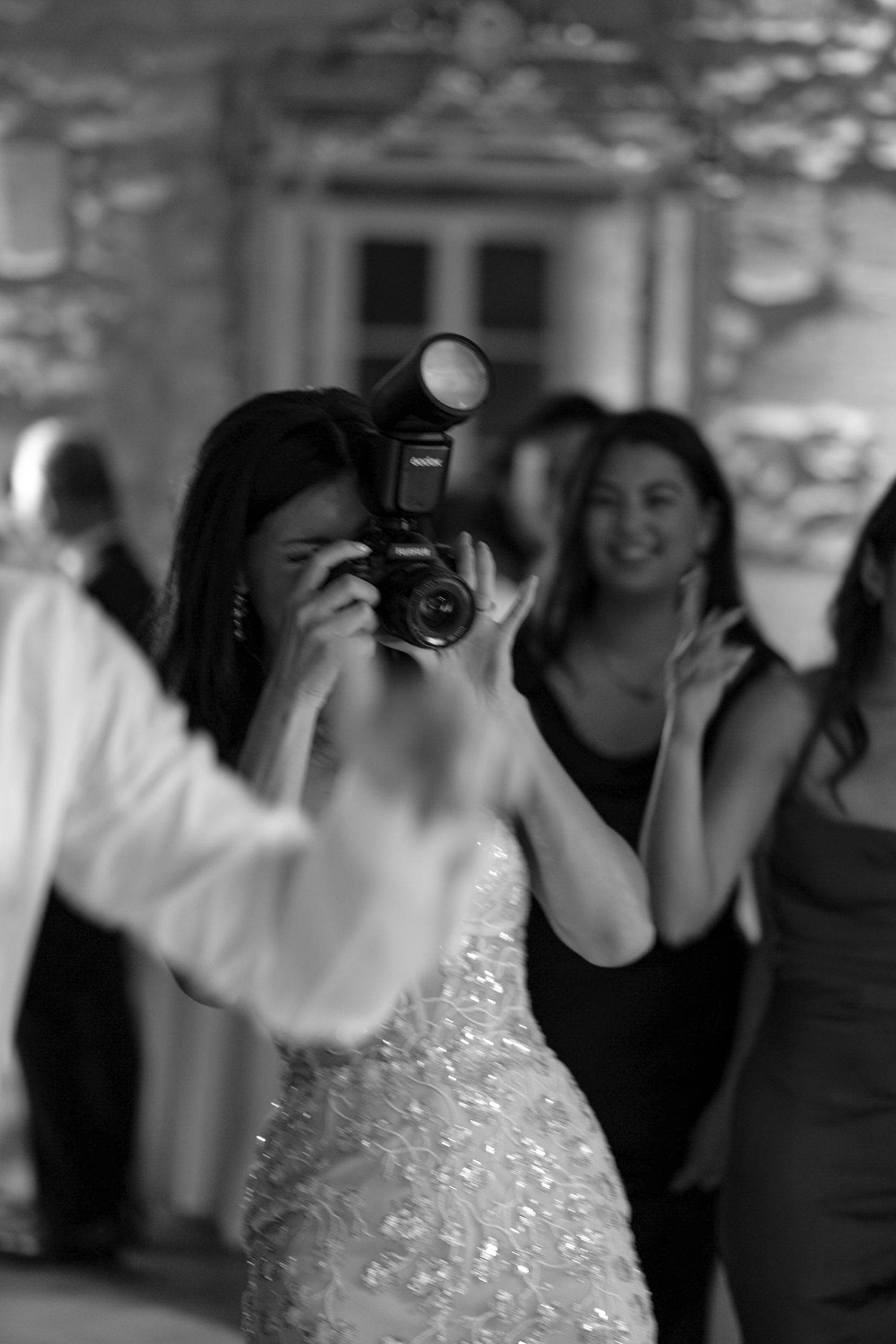 Photographer in sparkly dress capturing moments at formal event.