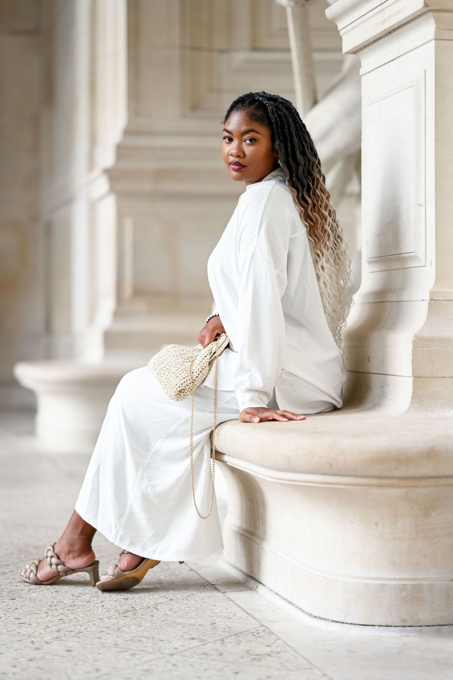 Fashion photo series showing elegant white dress against classical stone columns in natural light.