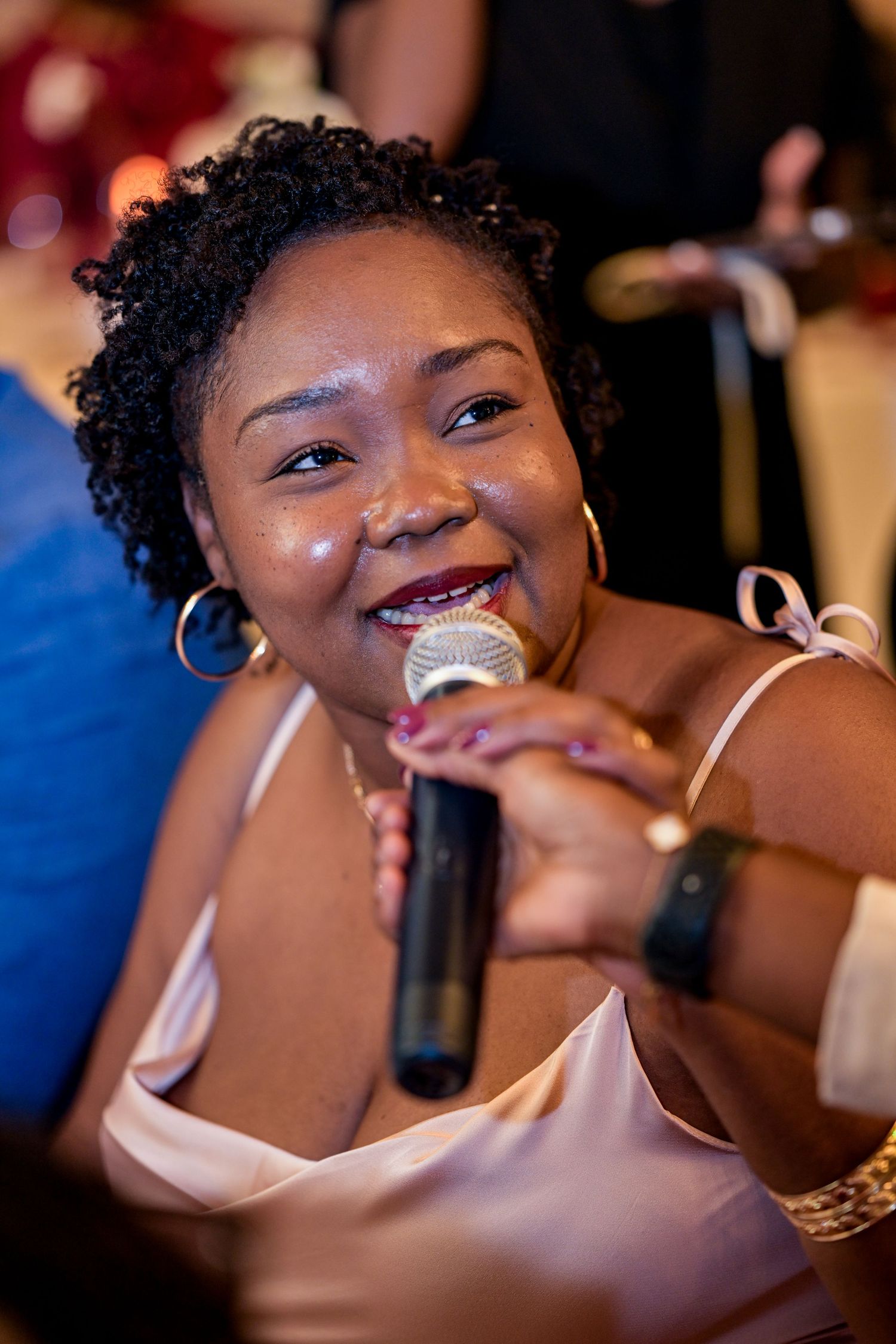 Joyful partygoers dancing and laughing together at an indoor celebration.