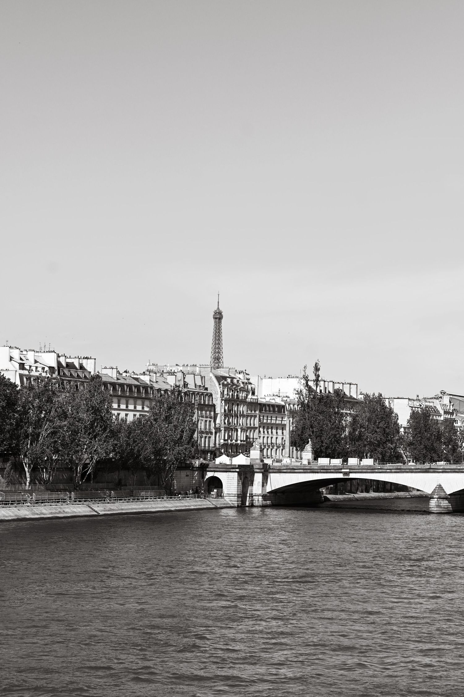 A black and white cityscape of Paris showing the Seine River and historic architecture.