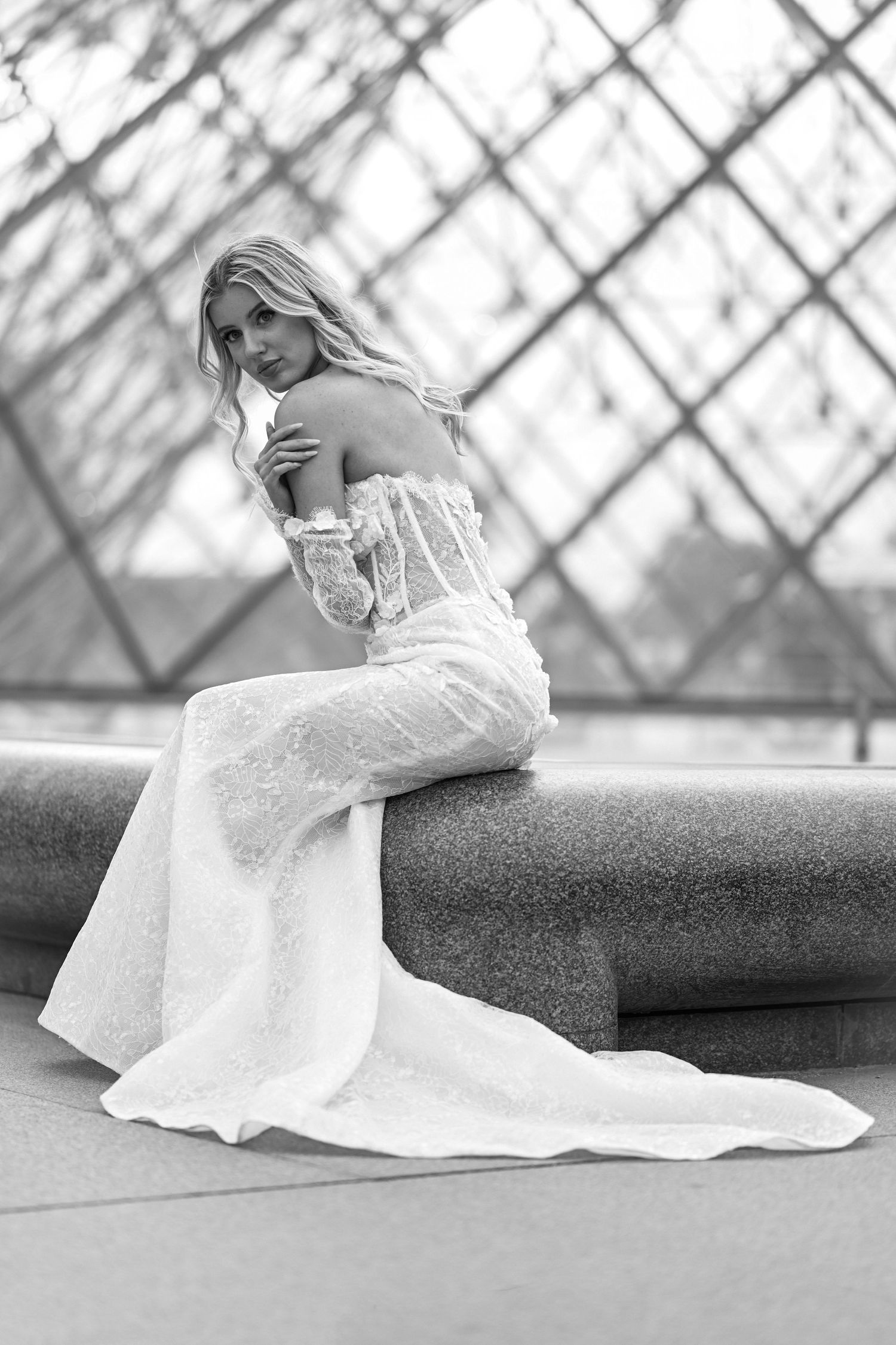 Black and white bridal portraits against geometric glass pyramid architecture.