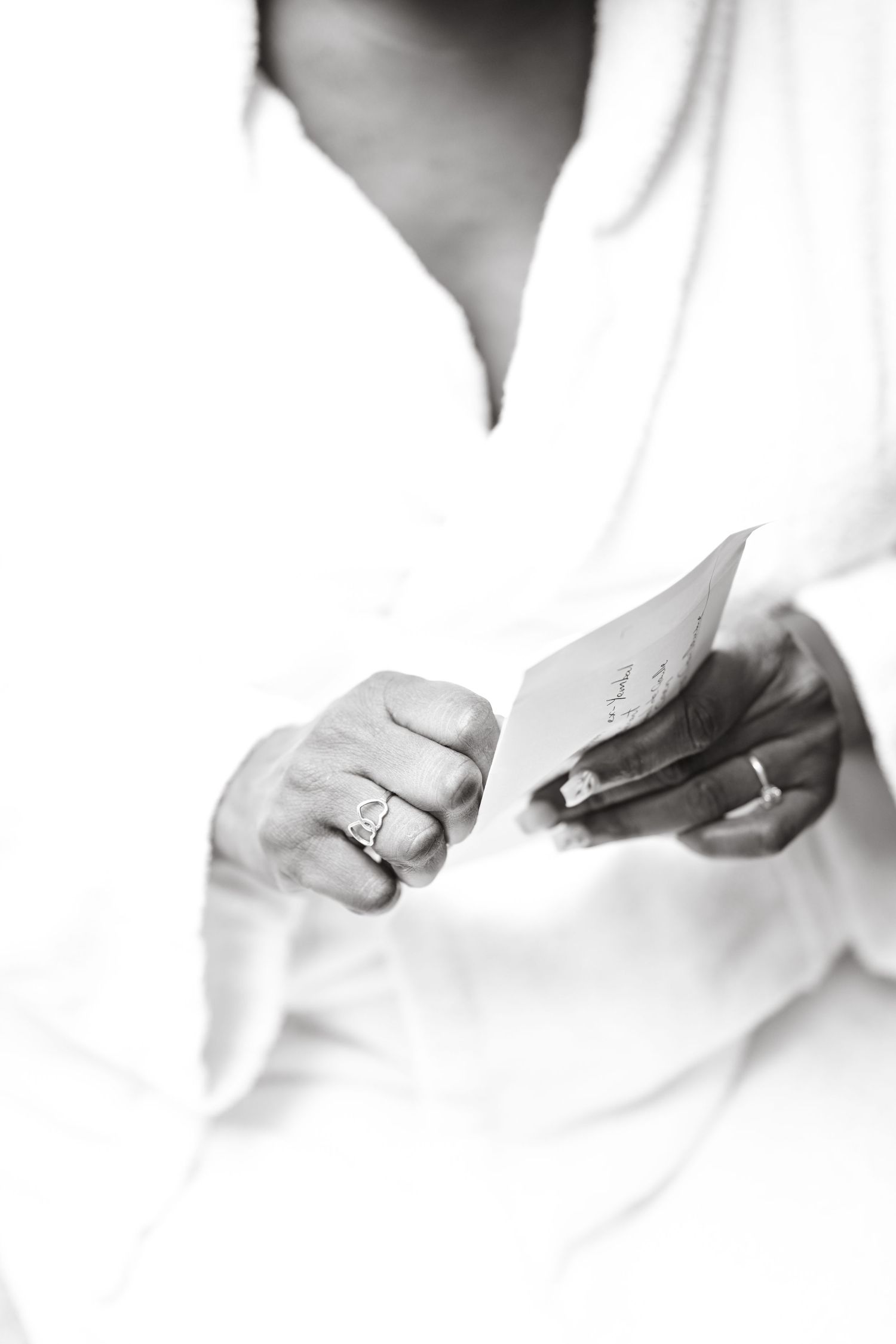 Close-up of hands holding small objects against white background.