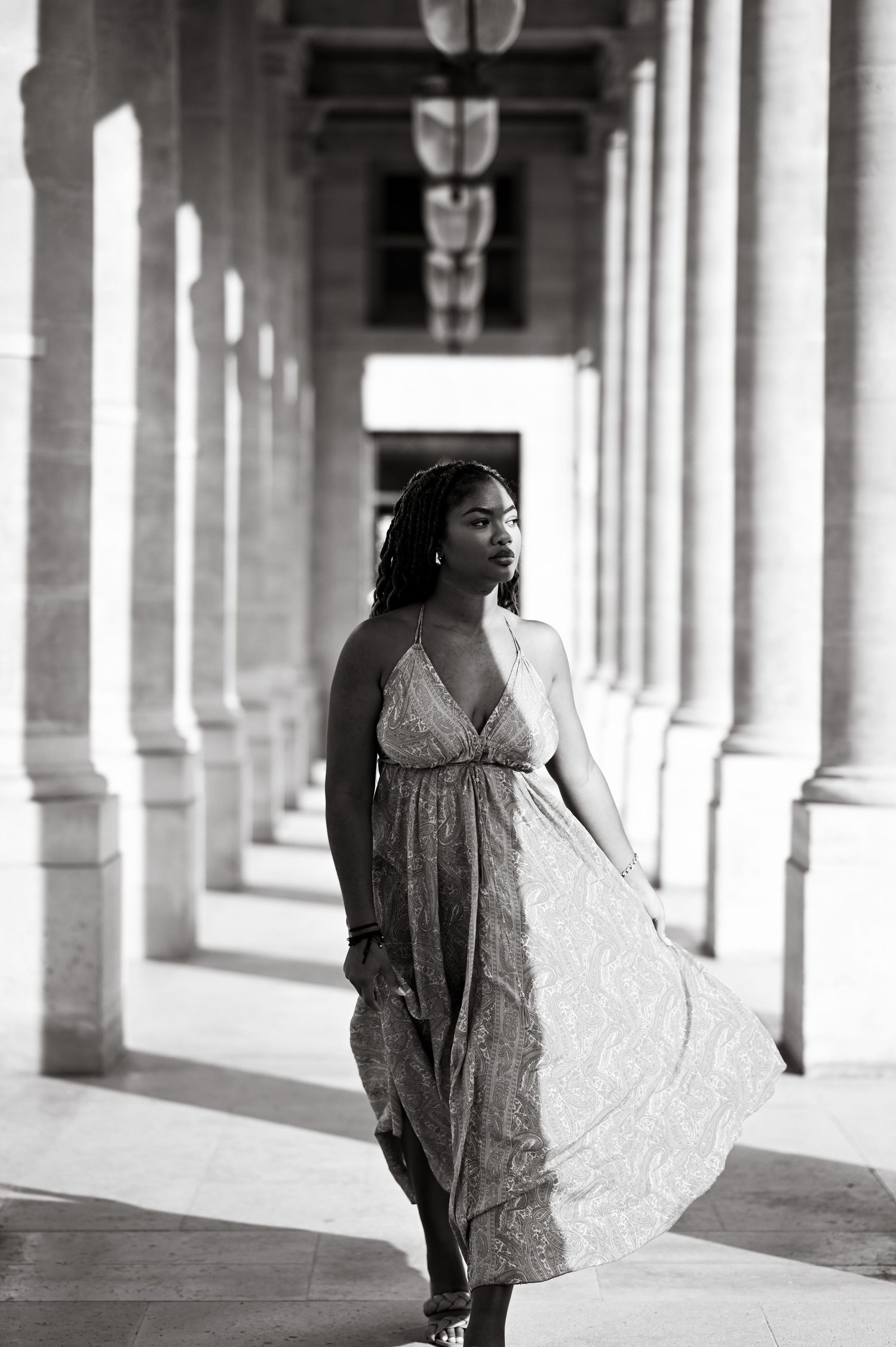 Dramatic black and white fashion portrait in an architectural colonnade setting.