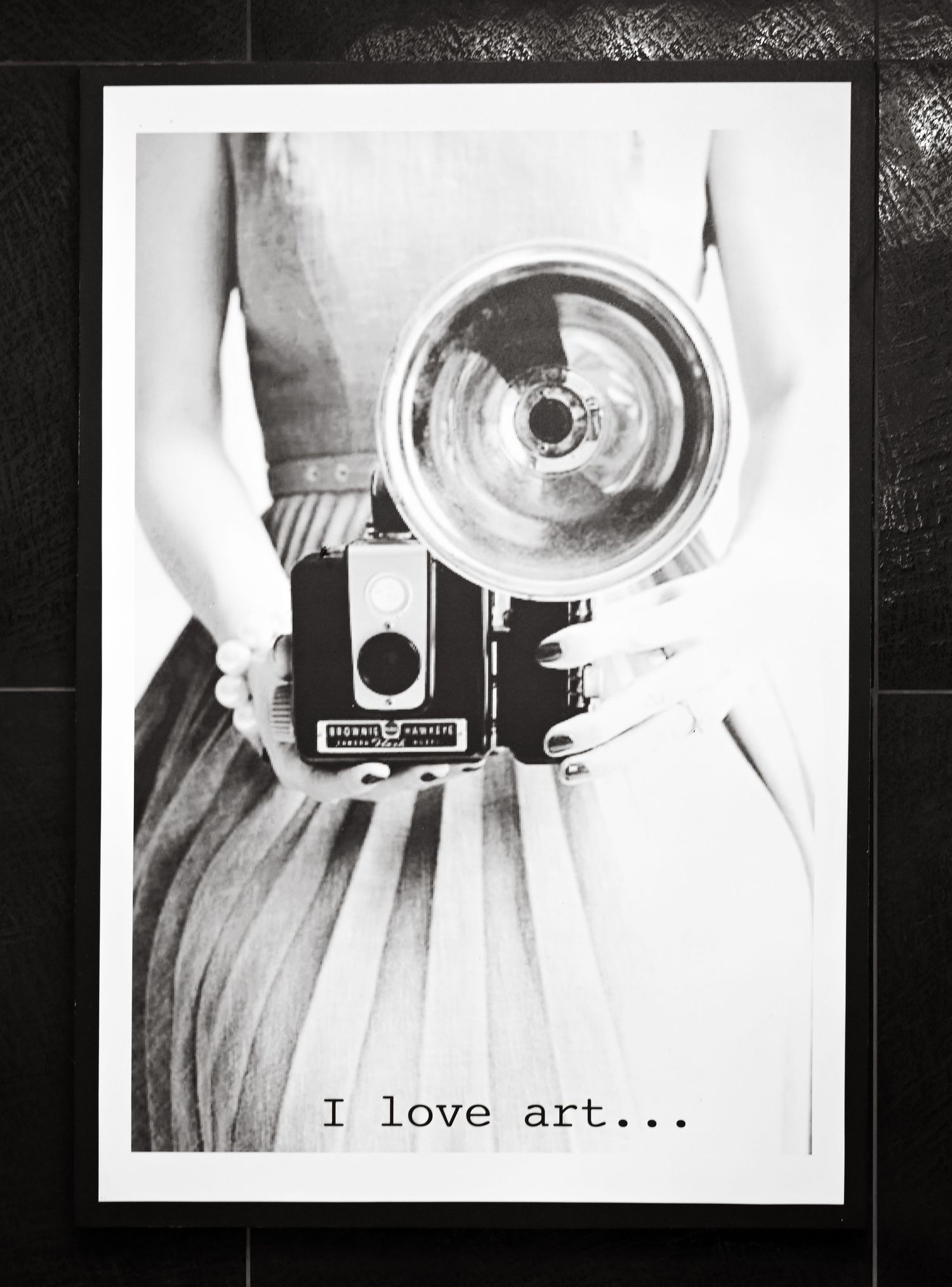 Vintage camera with 'I love art' text overlay in black and white artistic composition.