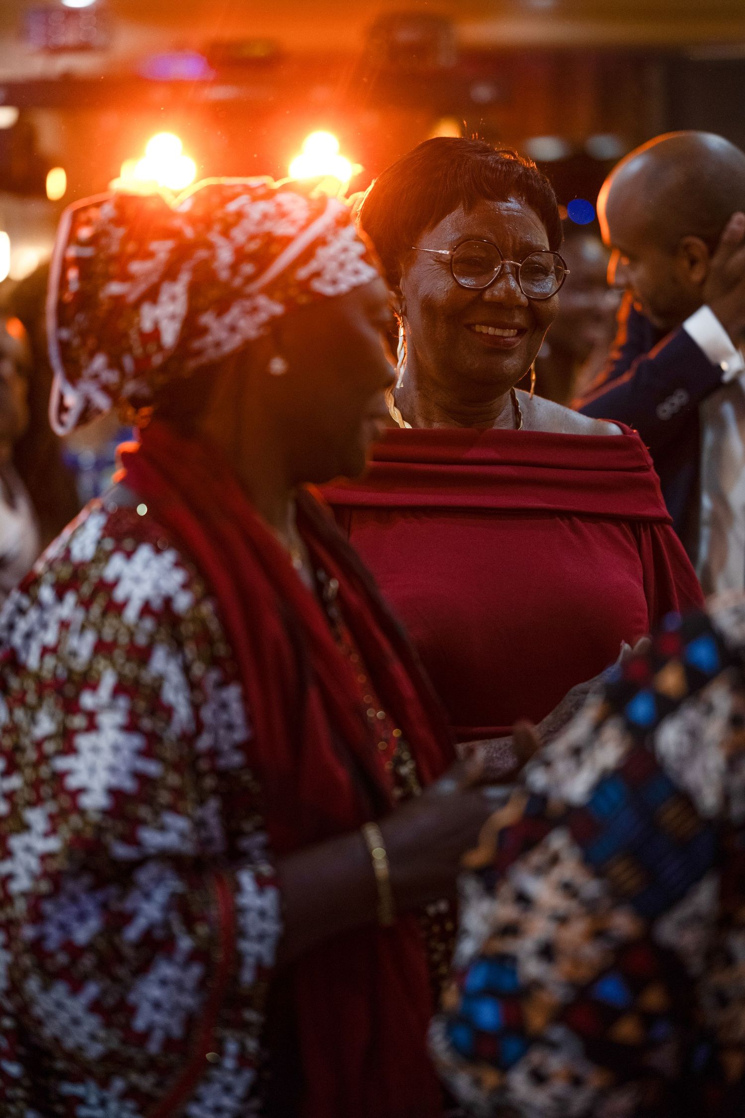 Celebration scene with warm lighting and traditional African clothing patterns.