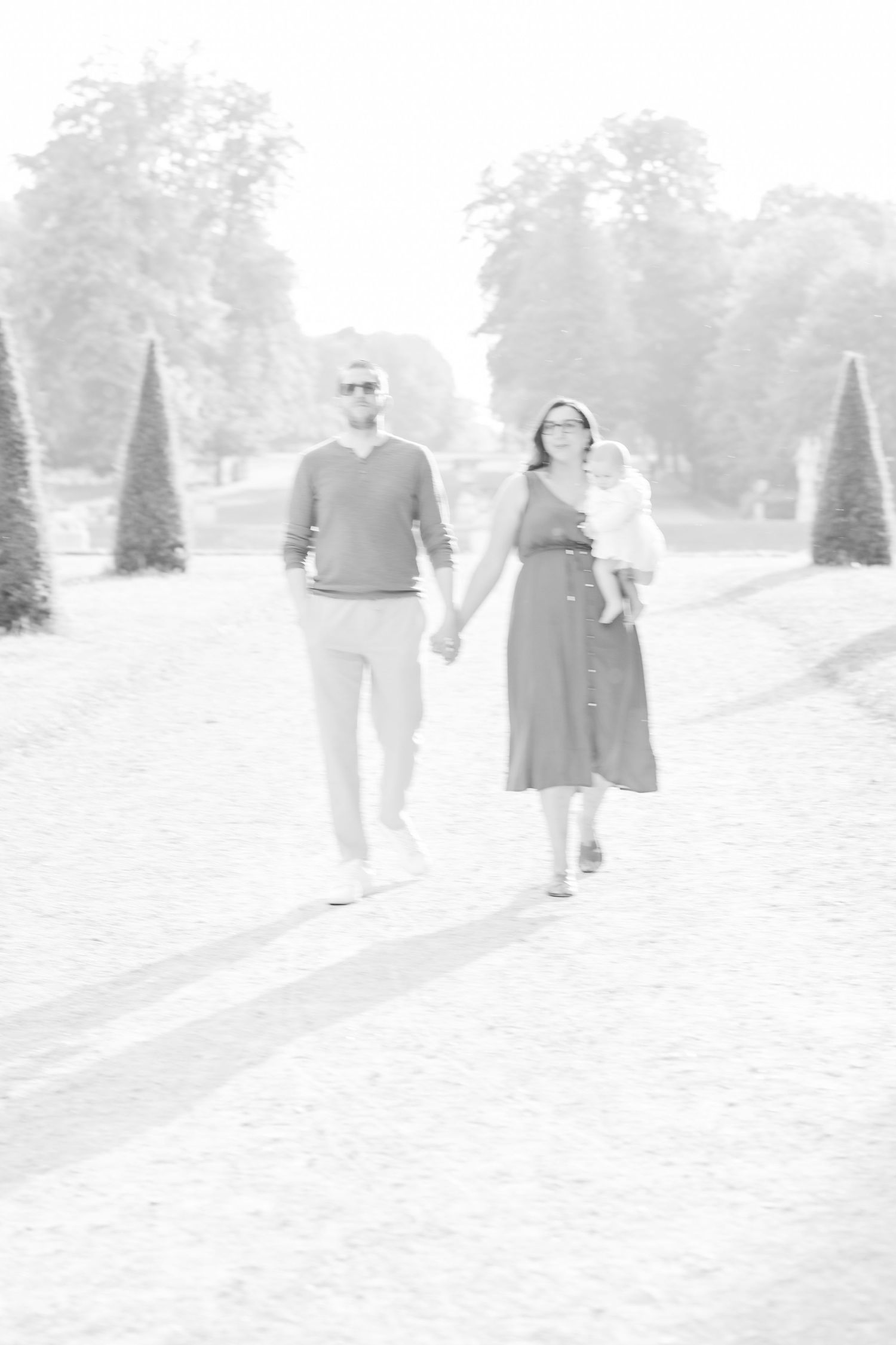 A couple takes a romantic stroll along a manicured garden path.