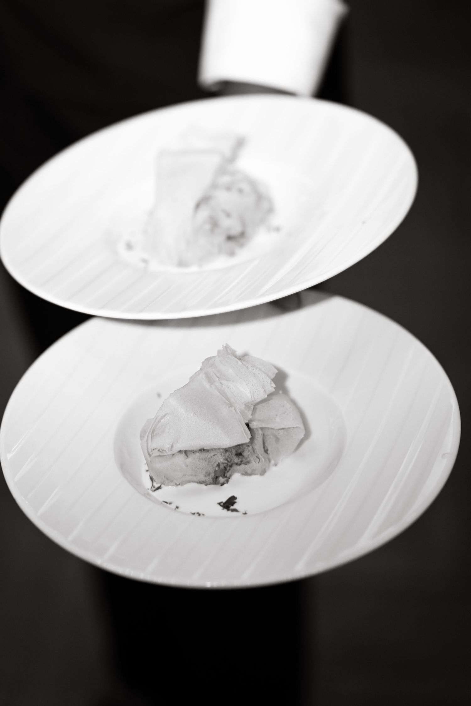 Black and white photo of plated food on white dishes.