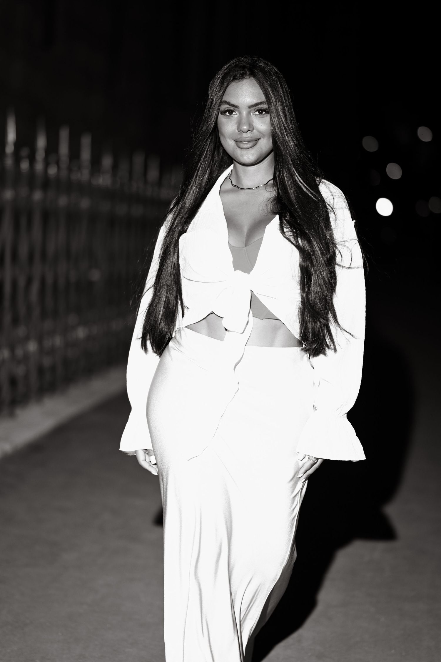 A black and white fashion photo featuring a modern white two-piece outfit with bell sleeves.