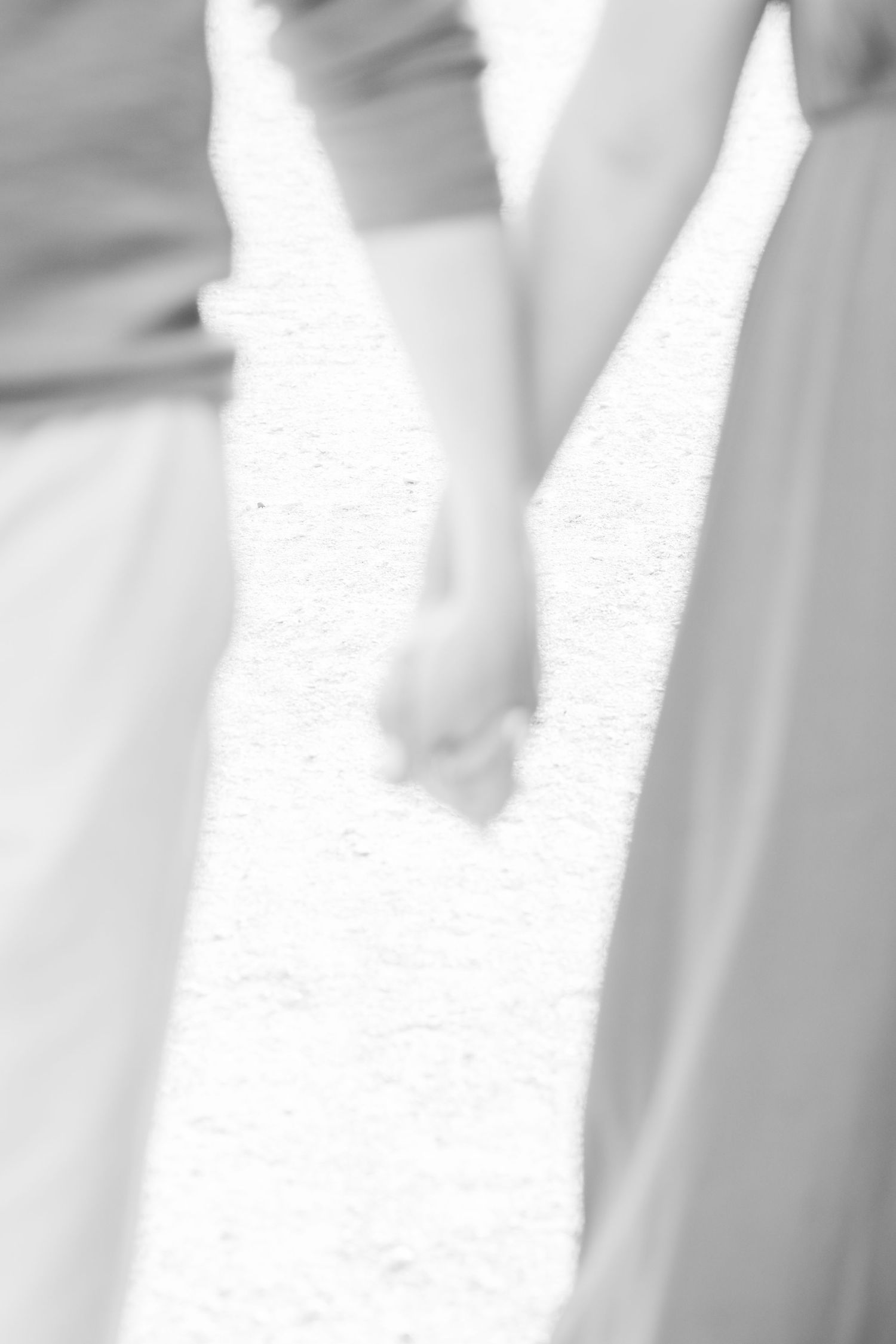 A soft focus black and white image of clasped hands.