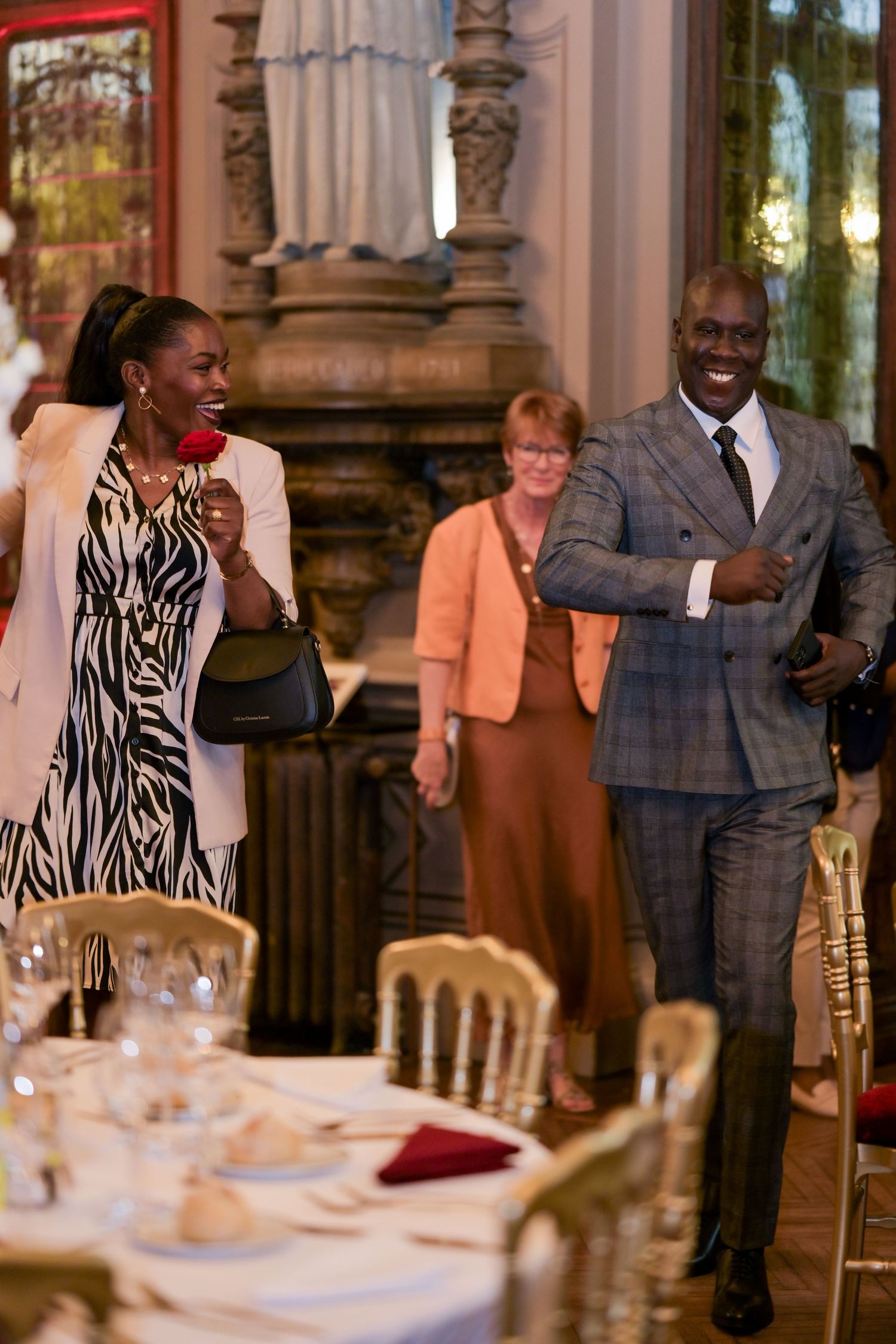 Guests sharing joyful laughter during an elegant wedding reception.