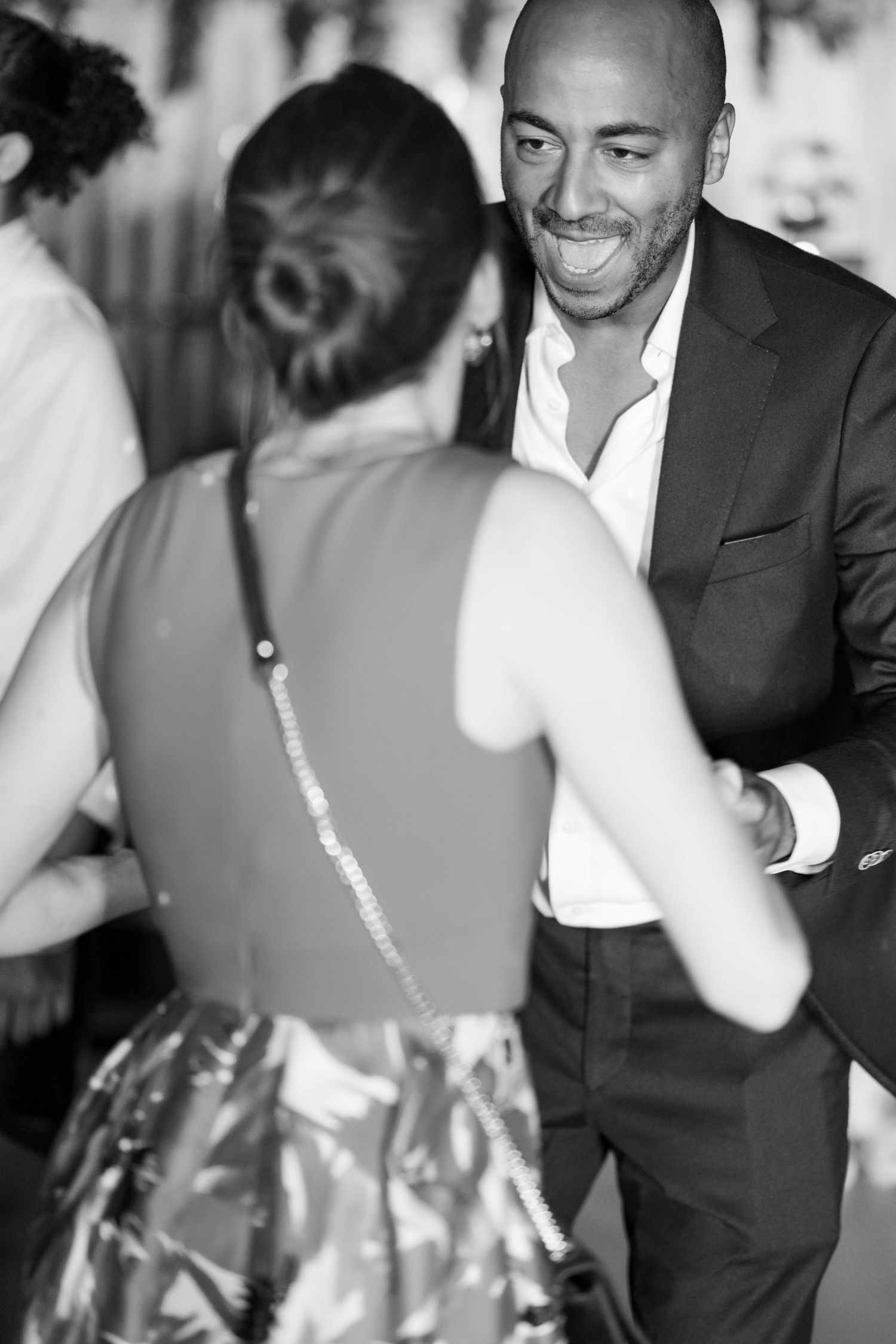 Guests dancing and smiling at formal celebration.