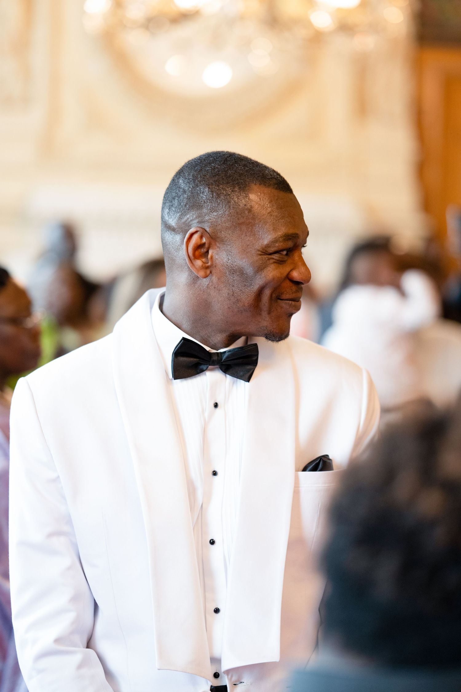 An elegant scene at a formal event with white tuxedo and bow tie.
