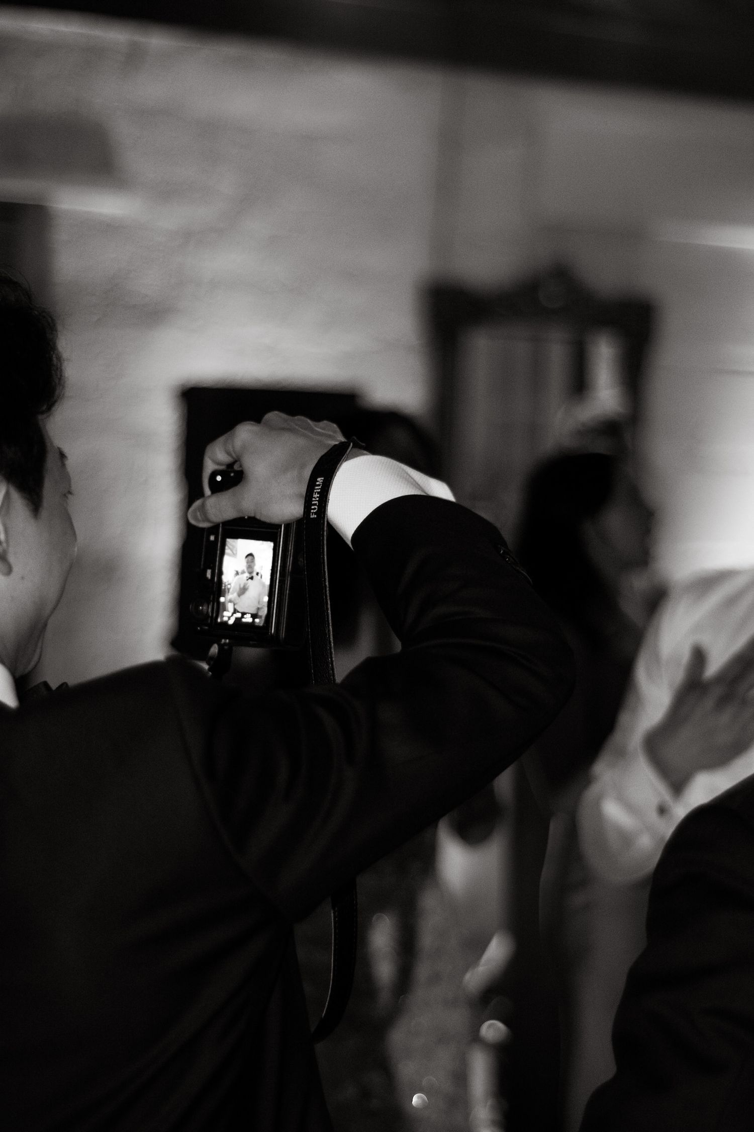 Guest taking photos with professional camera at formal event.