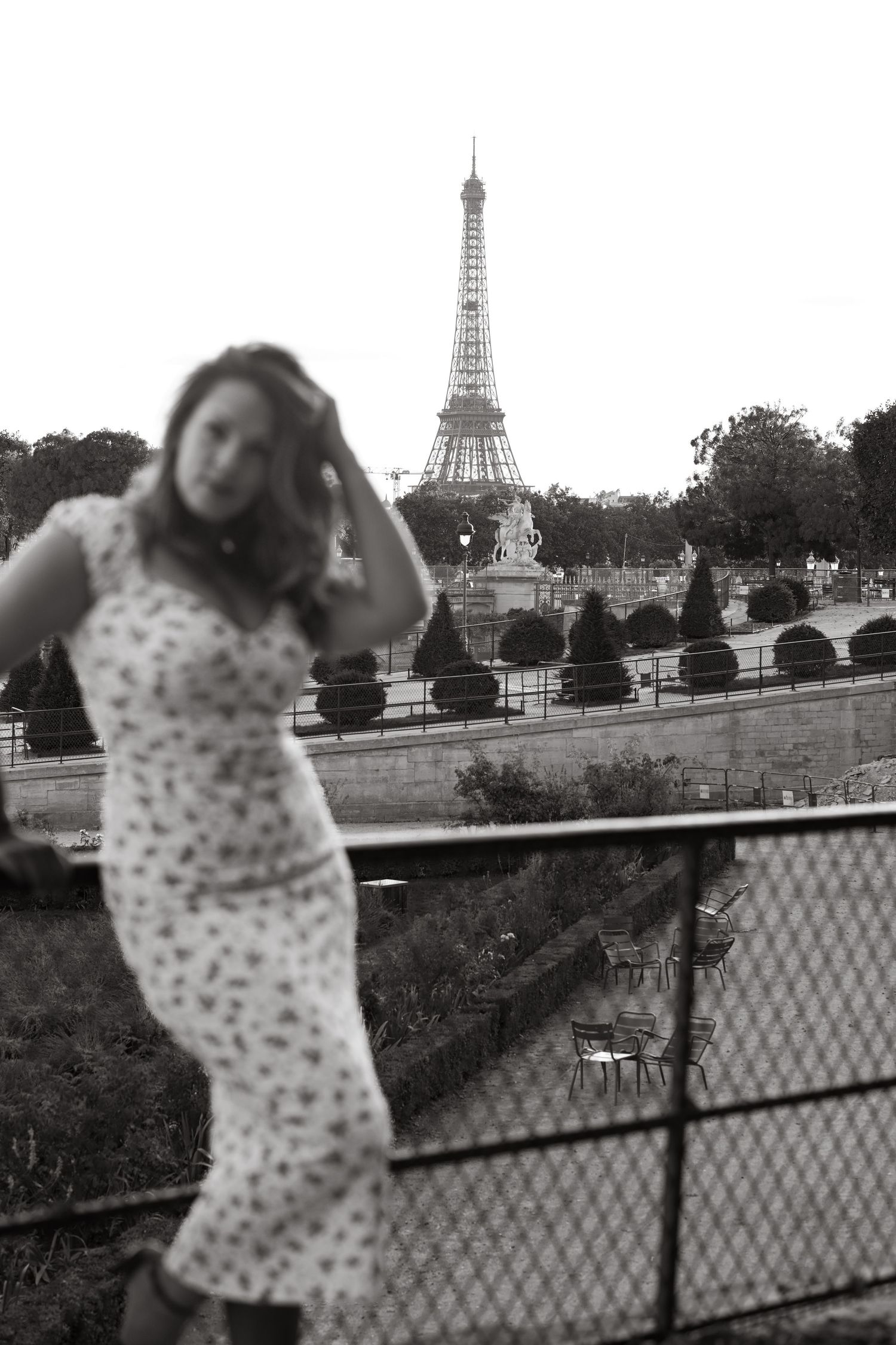 A vintage-style black and white photo showing a floral dress against the backdrop of the Eiffel Tower in Paris.