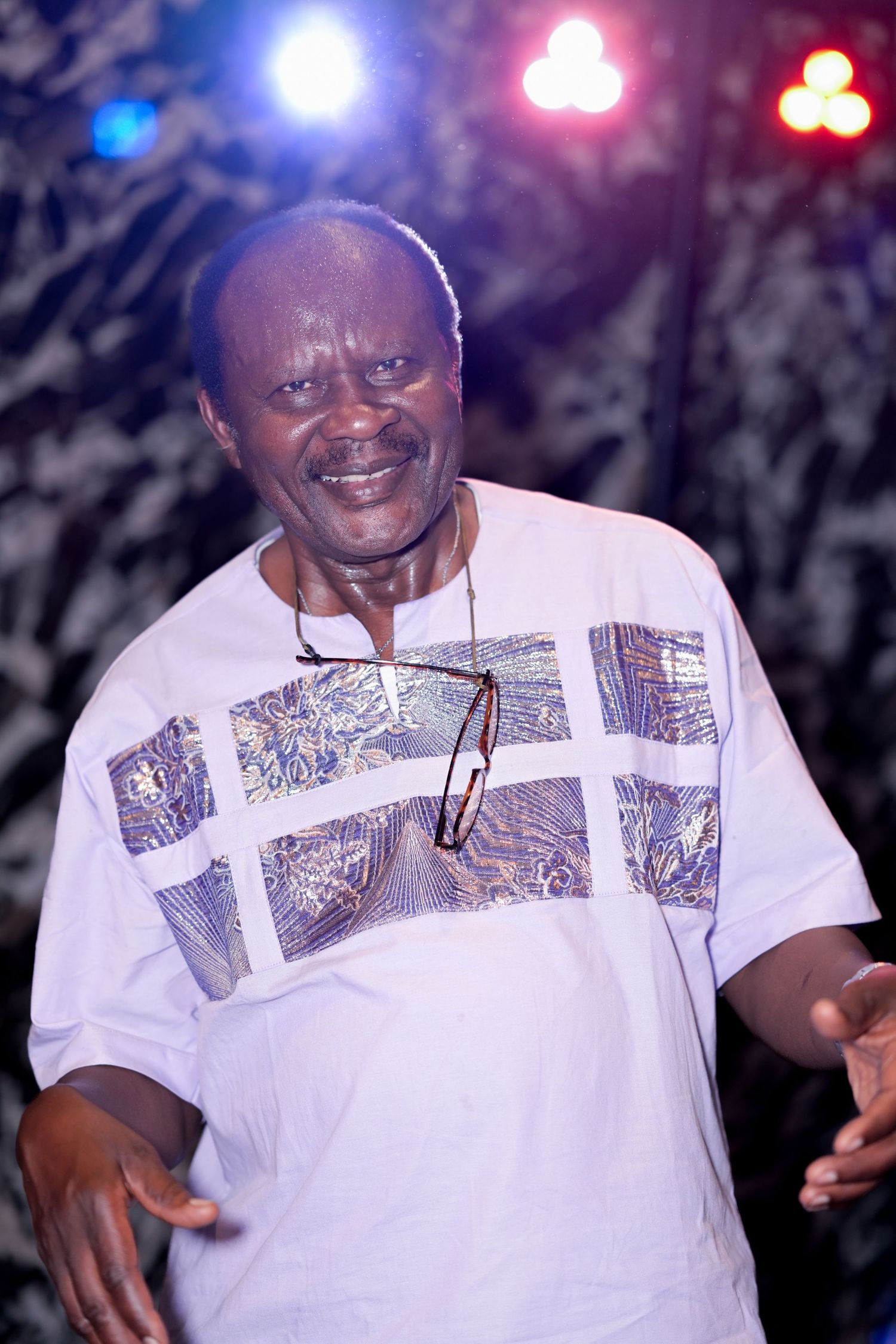 Person in white patterned shirt enjoying themselves at a party.