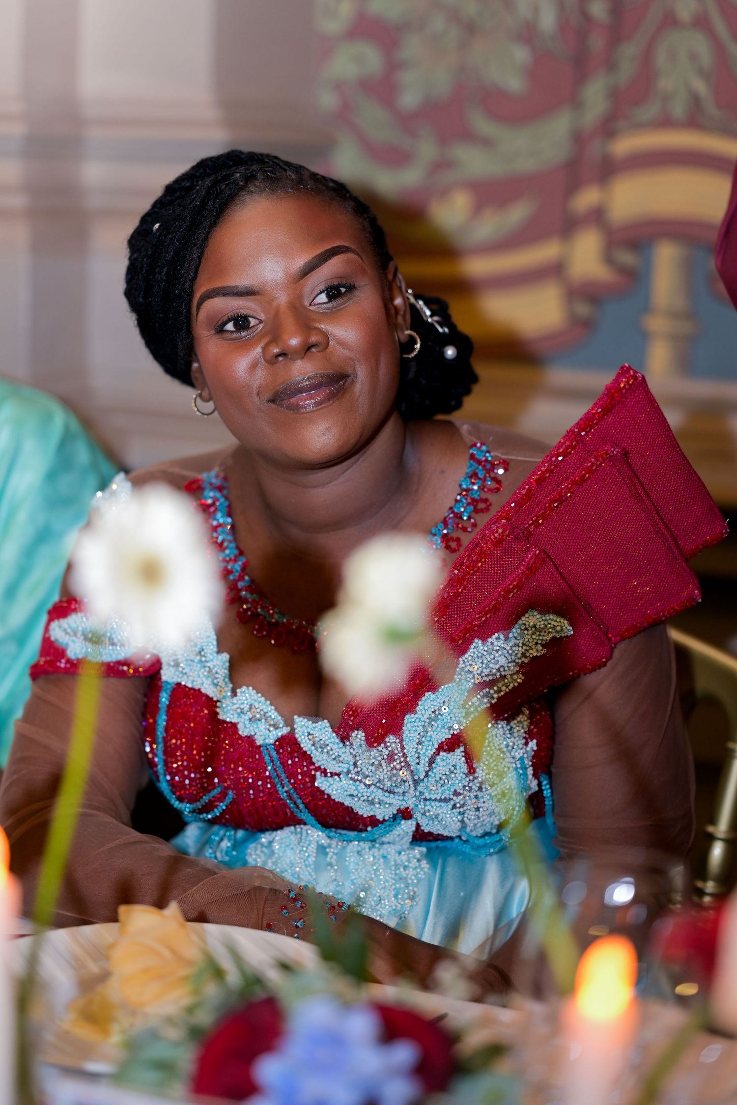 Guest in blue and red formal dress at elegant reception dinner.