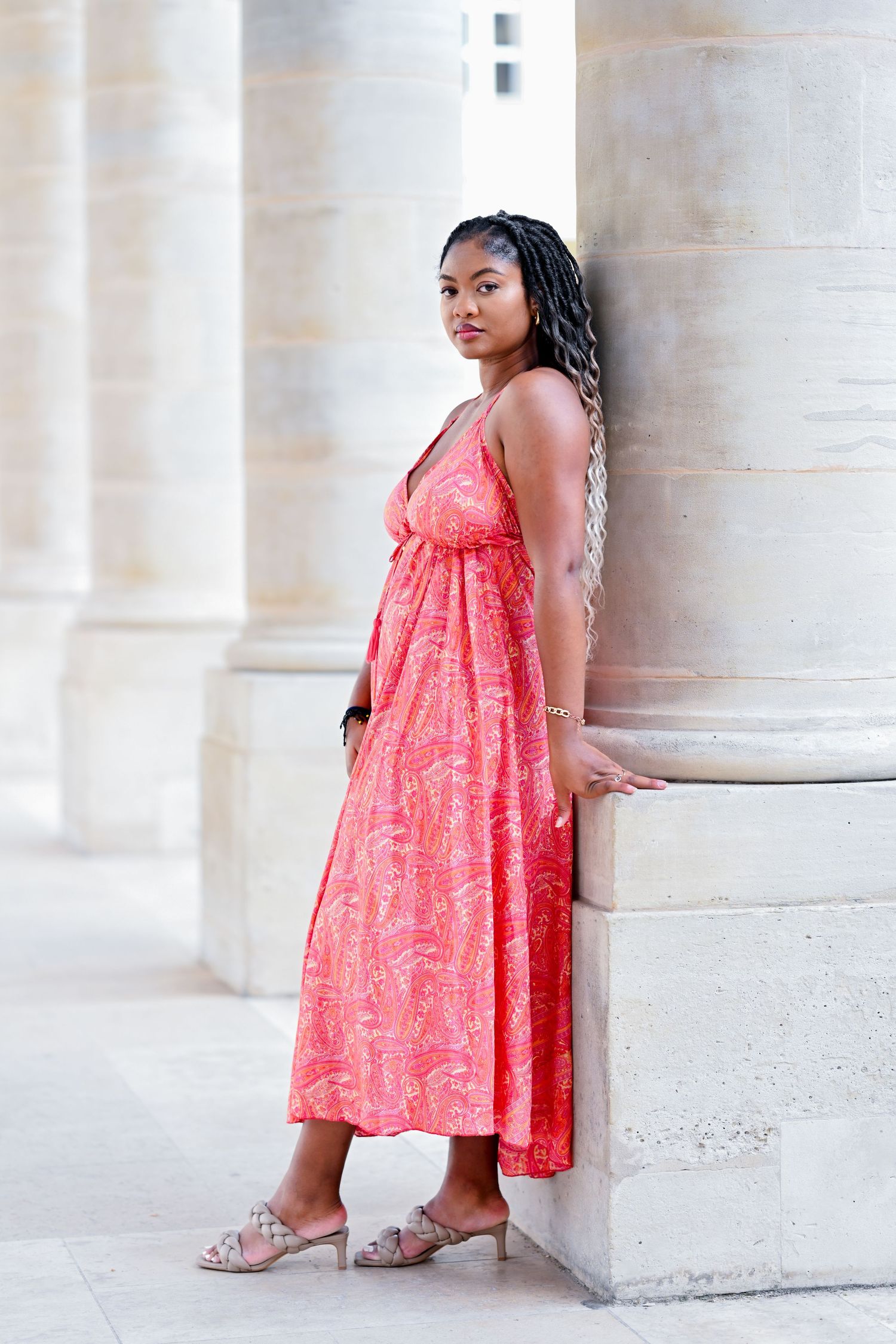 A summer dress photoshoot against classical architecture with elegant stone pillars.