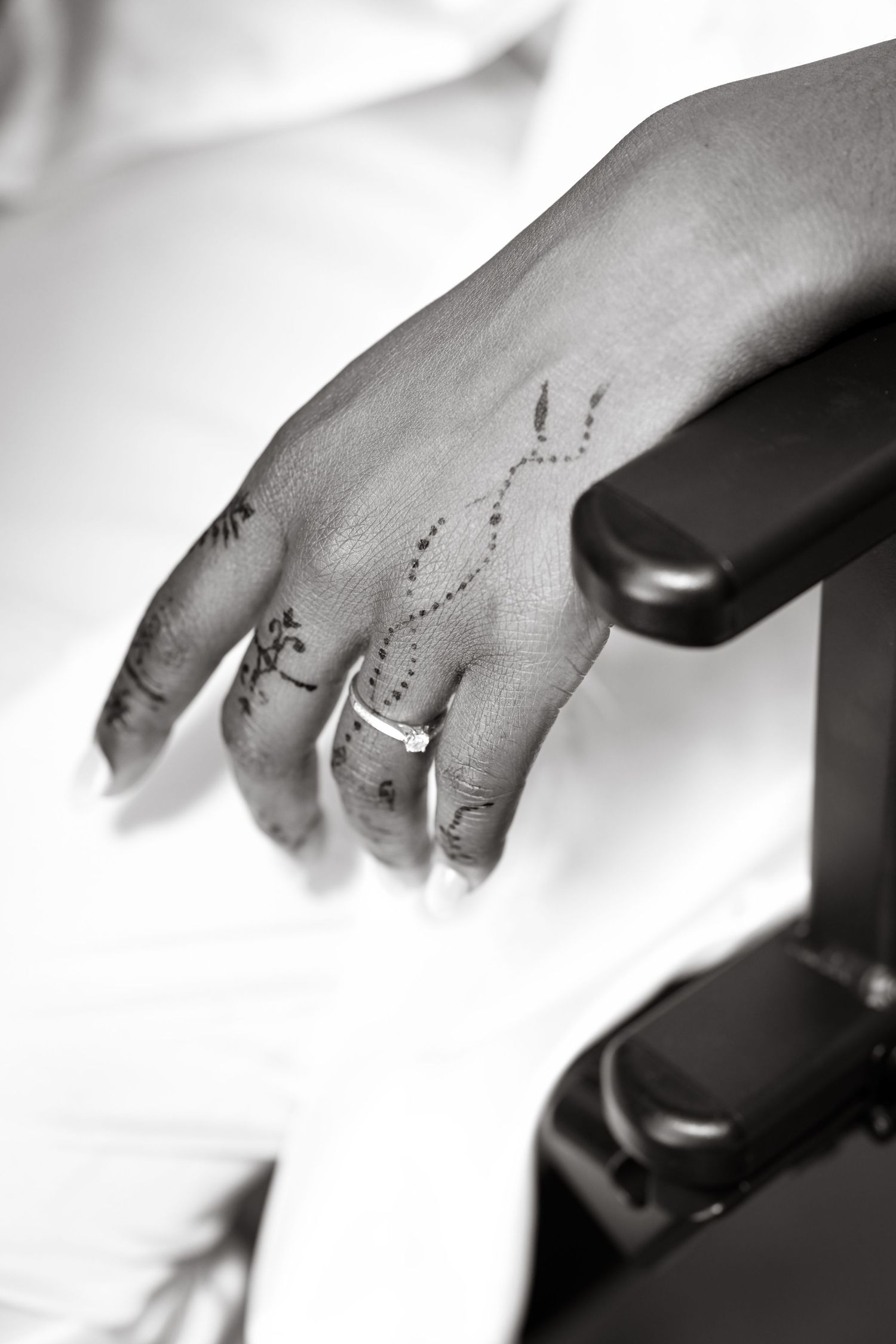 Close-up black and white shot of hands against dark background.