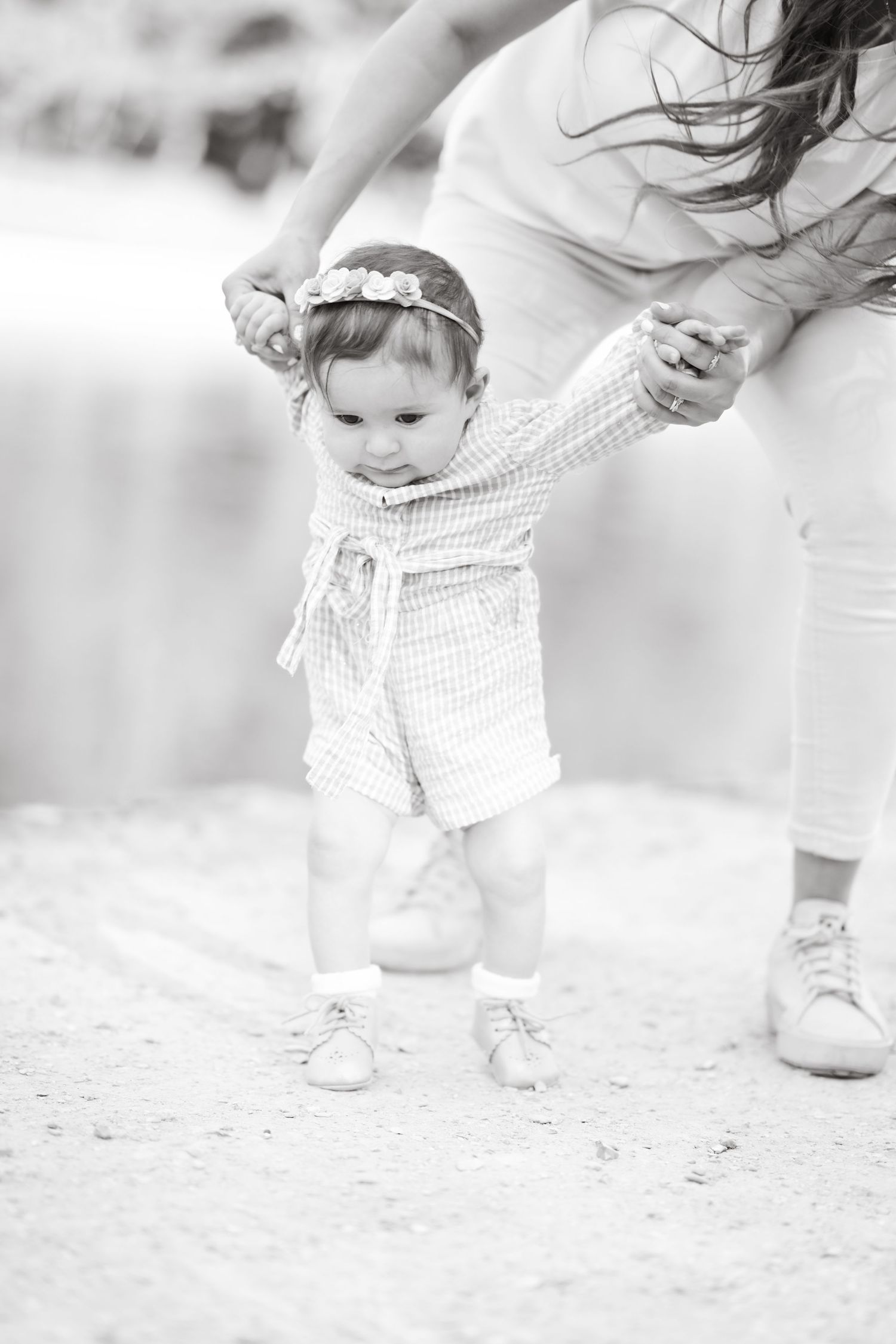 Black and white sequence showing steps of a small child learning to walk.