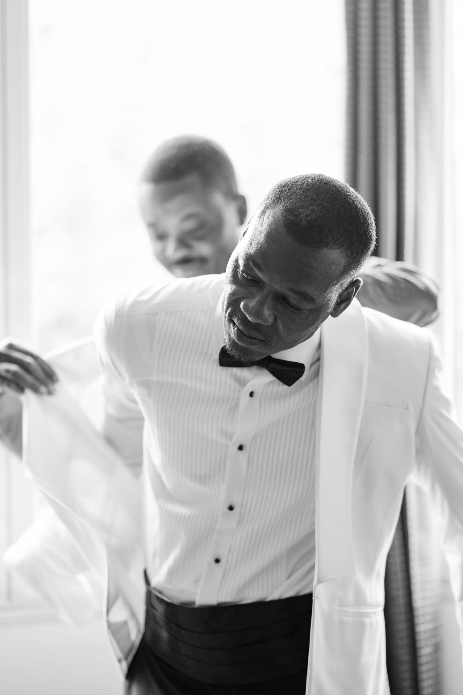 A joyful moment captured during wedding preparations in formal attire.