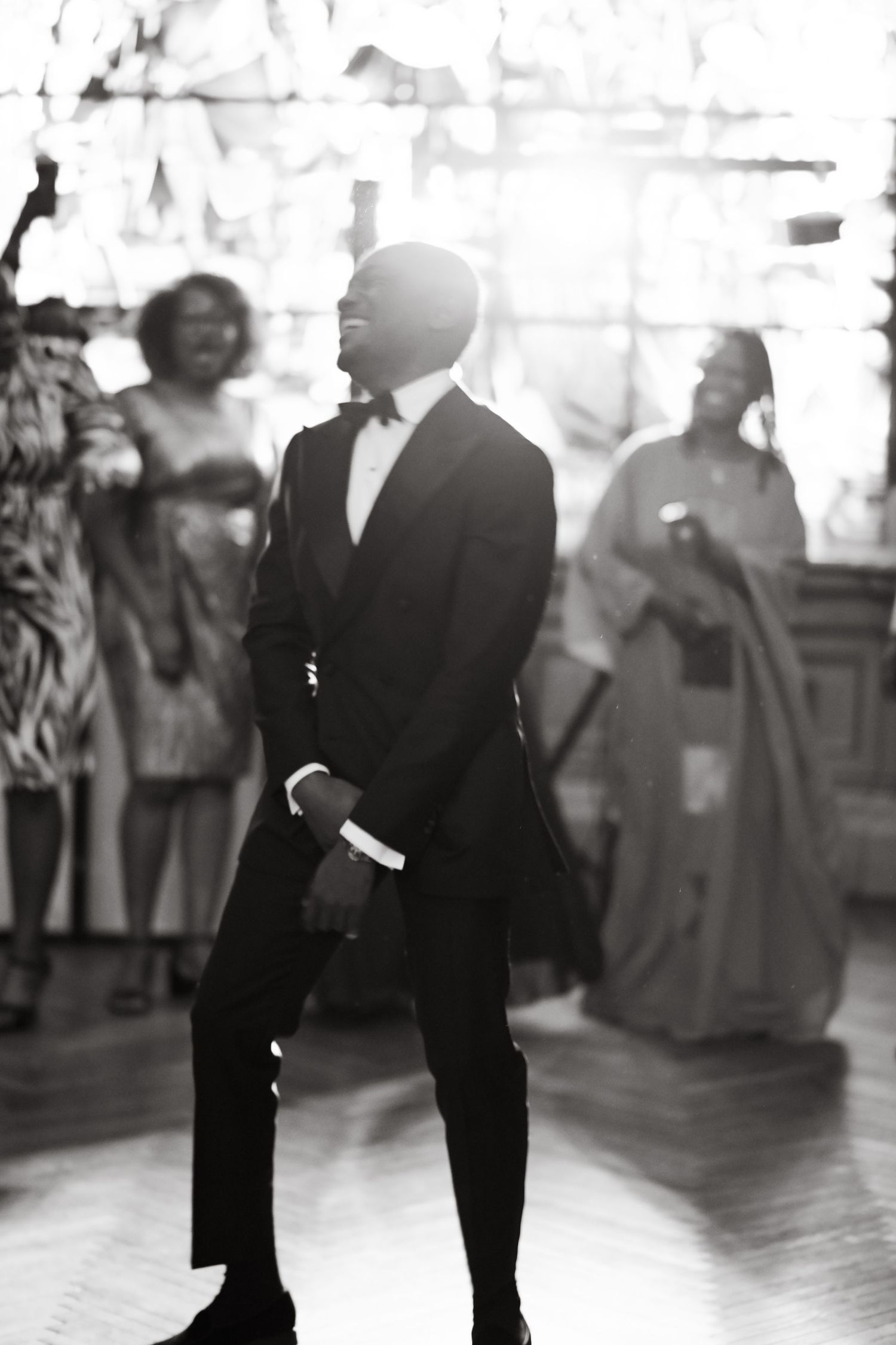 Black and white silhouettes of dancers in formal wear on a dance floor.